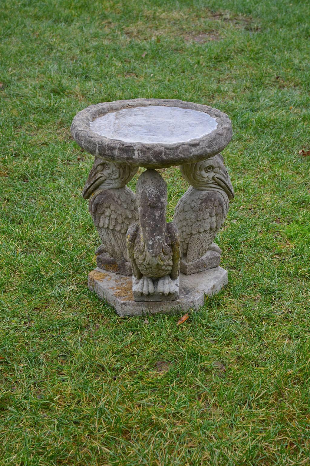 A charming composition stone birdbath with a trio of pelicans supporting a rustic bowl, the whole atop a hexagonal base, English, circa 1950. Measures: 22 ins. high, 19 ins. diameter.