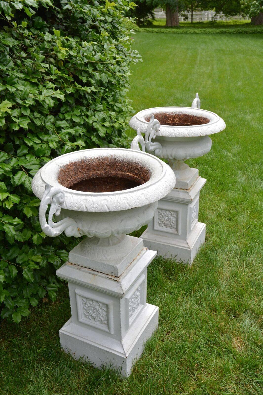 American A Pair of White Painted Cast-Iron Urns on Pedestals