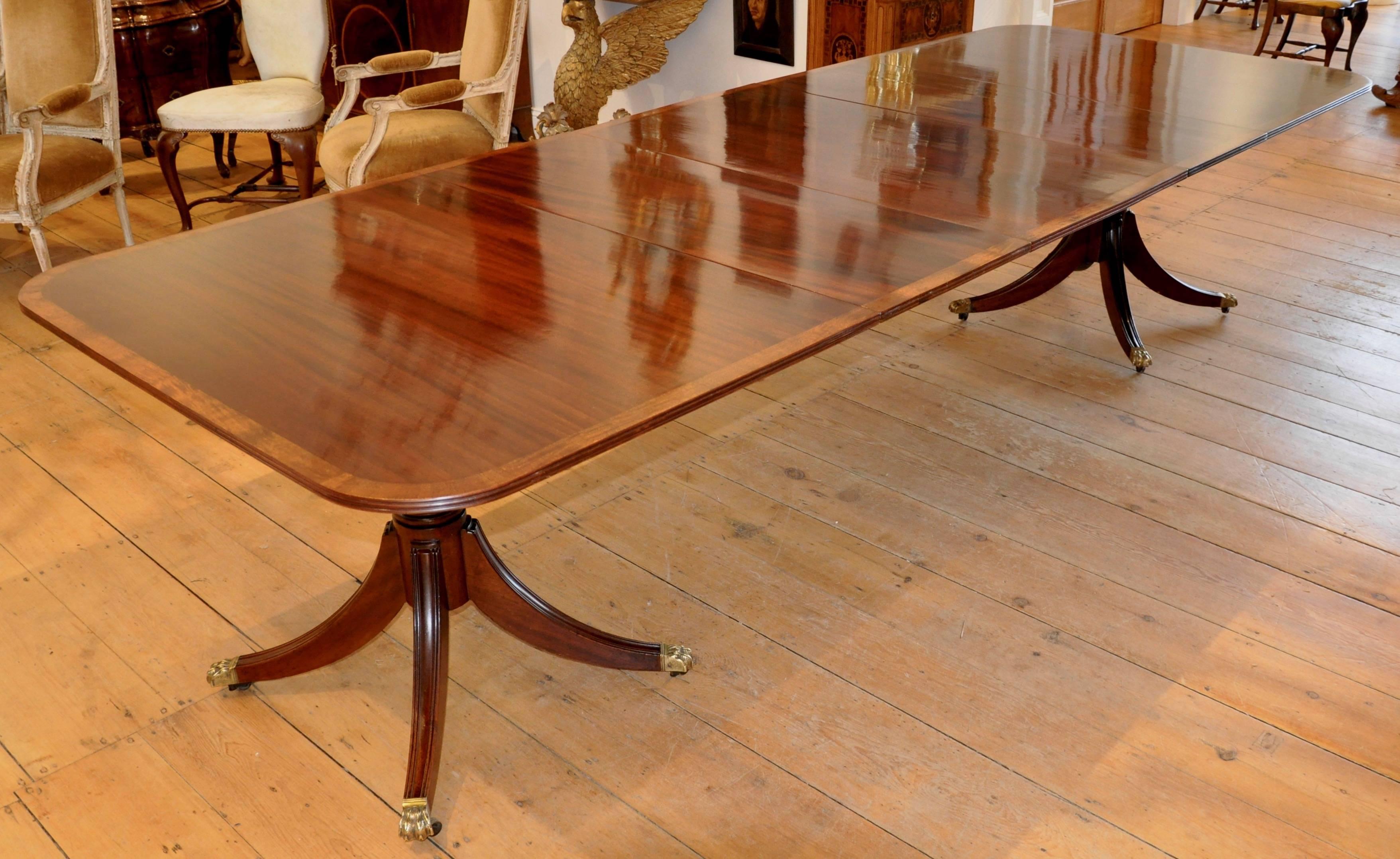 Early 20th century Mahogany two pedestal dining table
--Satinwood banded
--Rich Mahogany figuring
--Four leaves 

Closed with no leaves 68" long x 47" wide
Fully extended with four leaves 144” long.