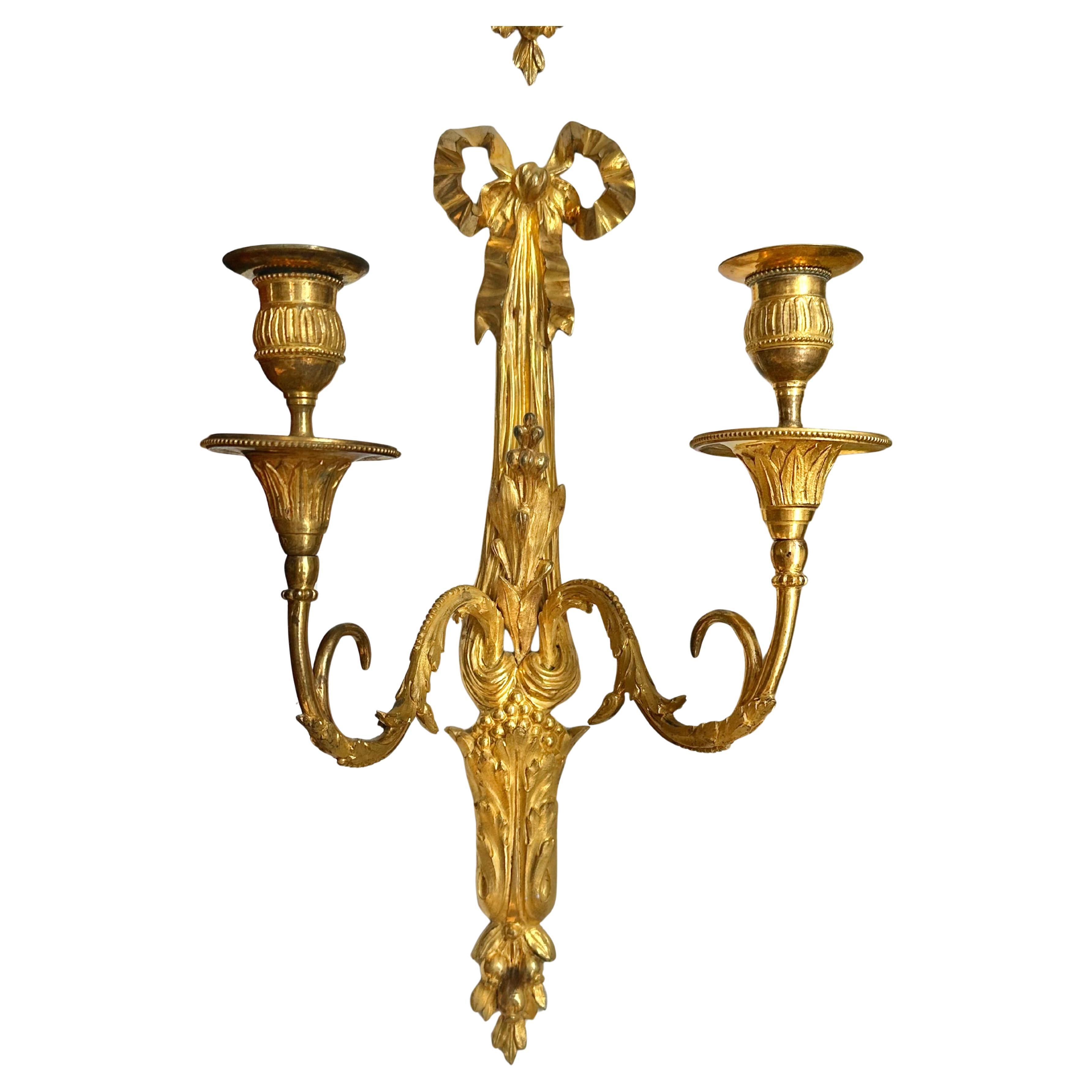 Coppia di lampade da parete o appliques in ormù Luigi XV del XIX secolo o precedenti.  Due bracci ciascuno con nastro e fiocco posteriore, bracci foliati che terminano in coppe di candele foliate.

Provenienza: Importante collezionista di Boston