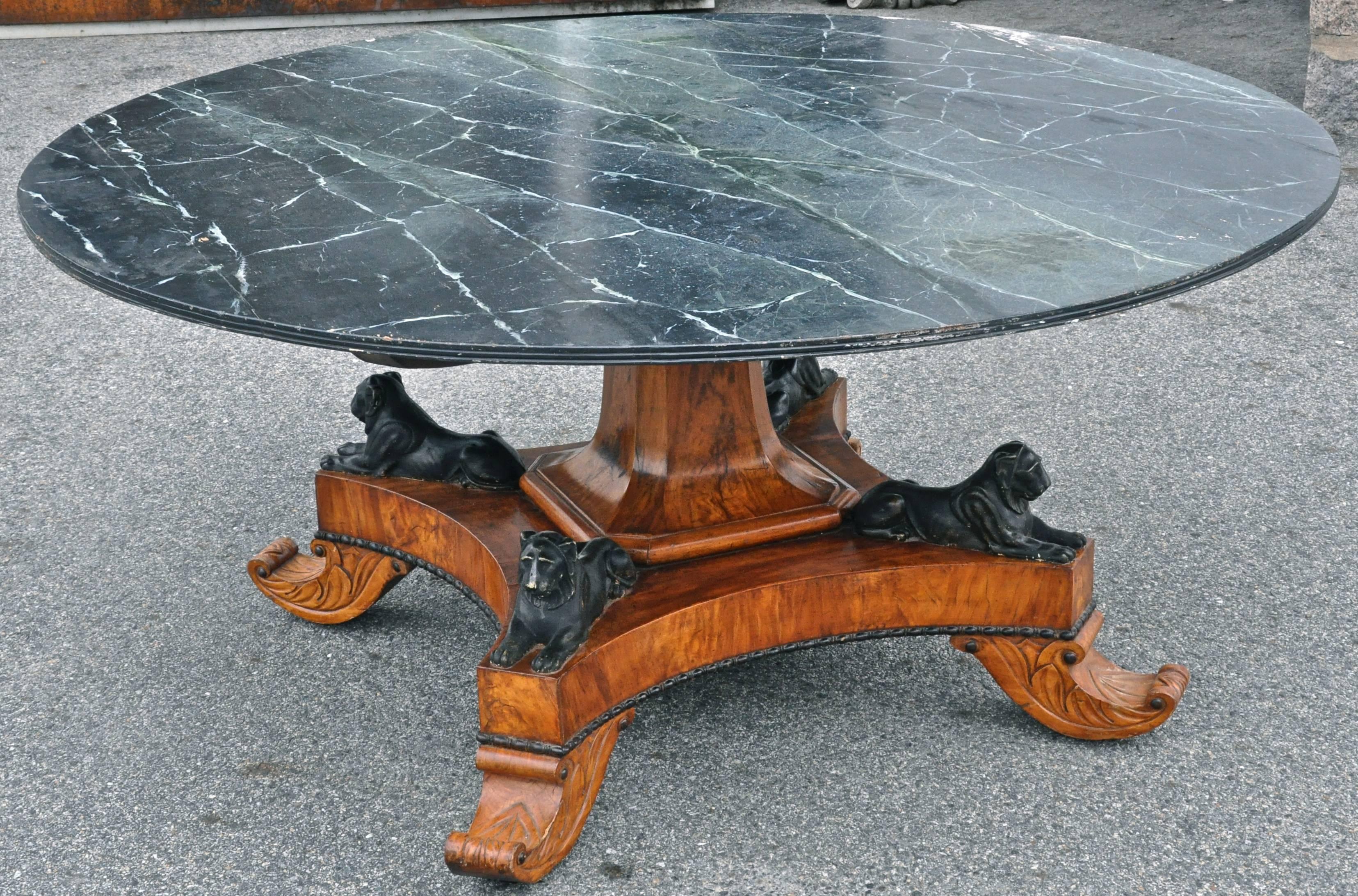 Neoclassical walnut round dining table in style of Thomas Hope.

Beautifully figured crotch walnut pedestal with four Egyptian recumbent lions bearing strong similarity to designs by Thomas Hope.
Large tilting top in later faux paint, though by