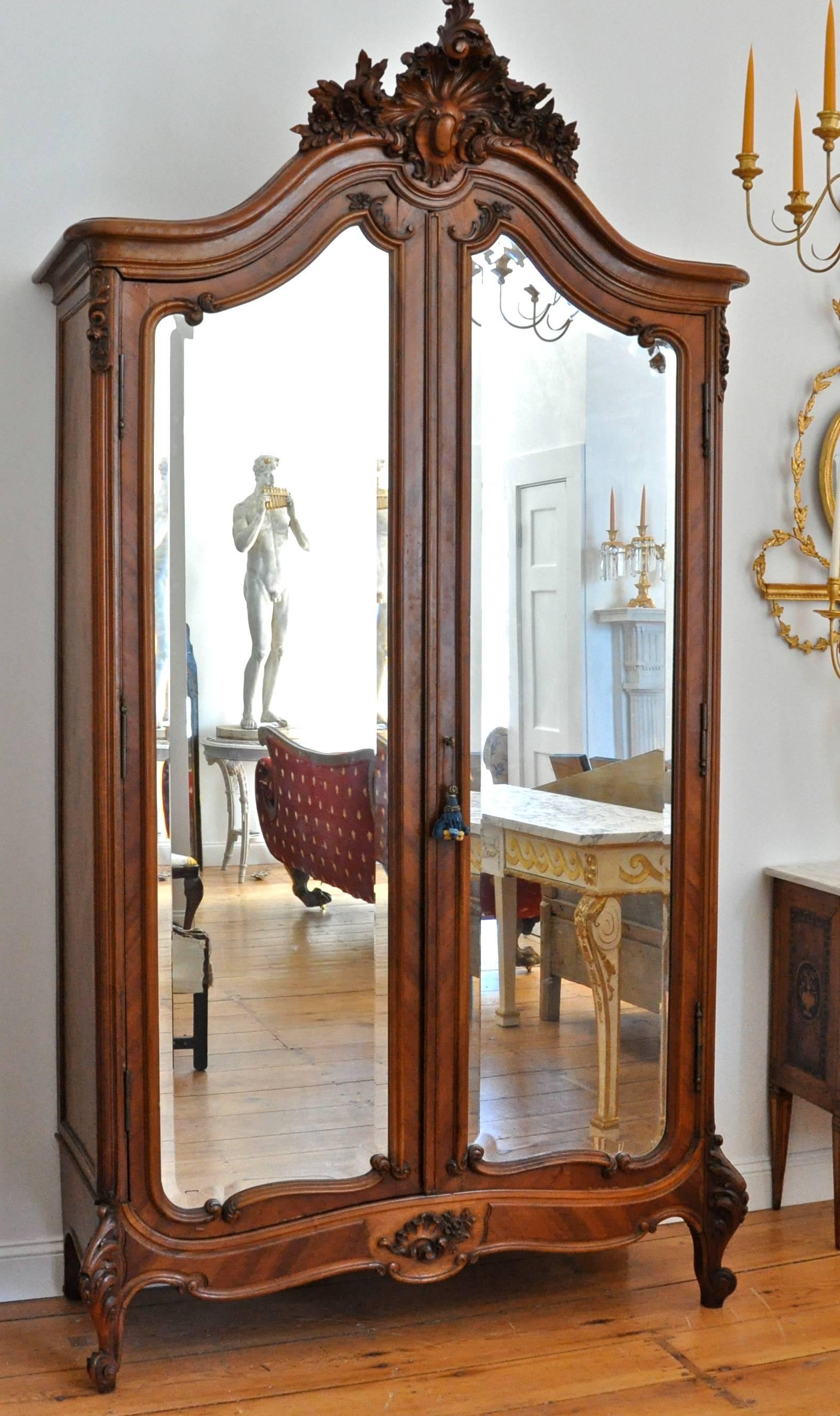 Walnut Louis XV style mirrored two-door armoire in walnut

Carved walnut cartouche with marquetry walnut veneers
Interior finished in bird's-eye maple
Disassembles for transport and installation into any interior space
Beautifully carved