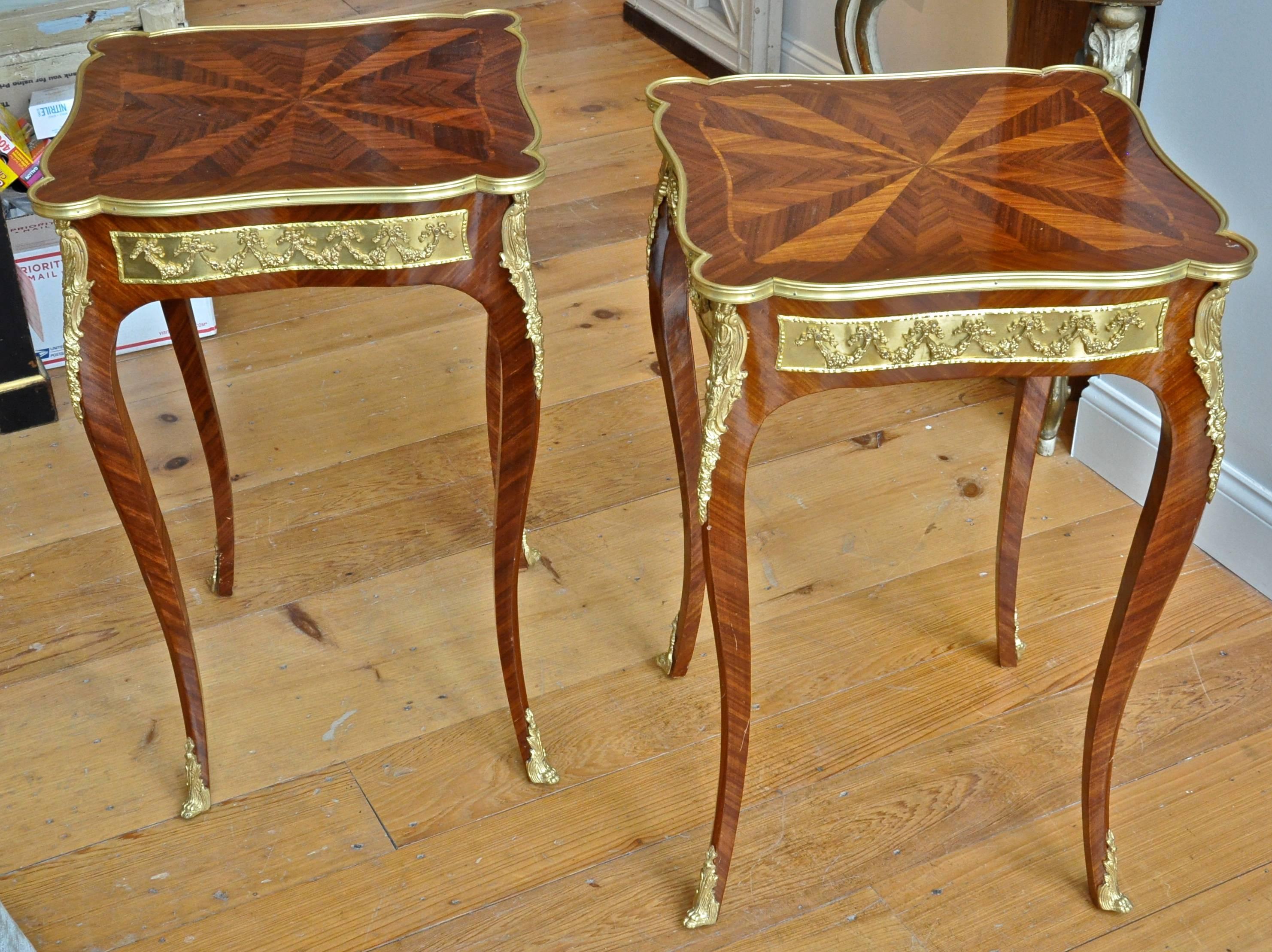 Pair of French Louis XV side tables in kingwood

Cabriole legs with sabot feet
Ormolu frieze of floral swags on all sides
Marquetry suburst top