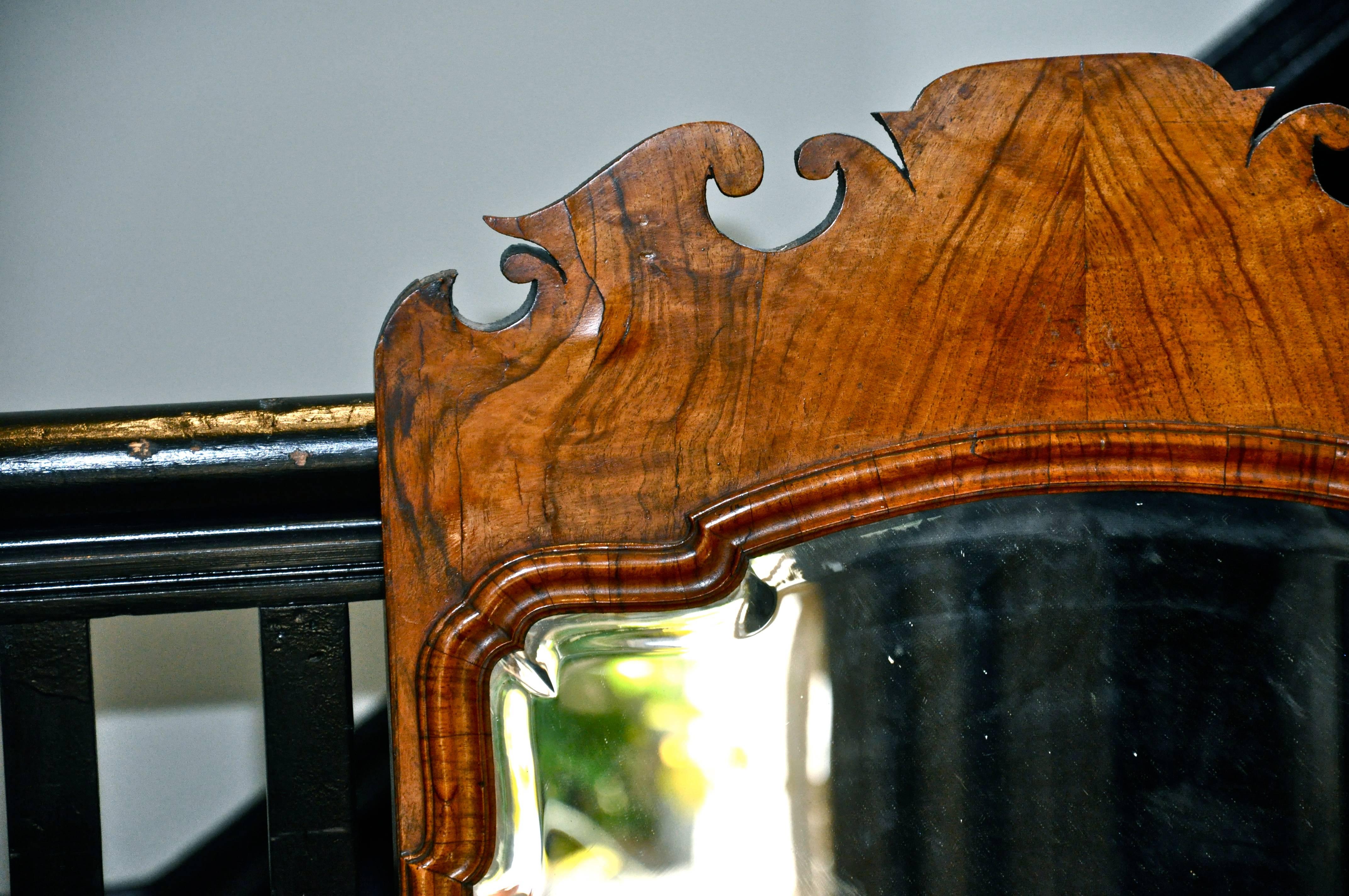 Pair of beautiful George II style mirrors

Well figured bookmatched walnut
Bevelled hand cut mirror, original silvering
Each with original Georgian candleholders

Provenance: 