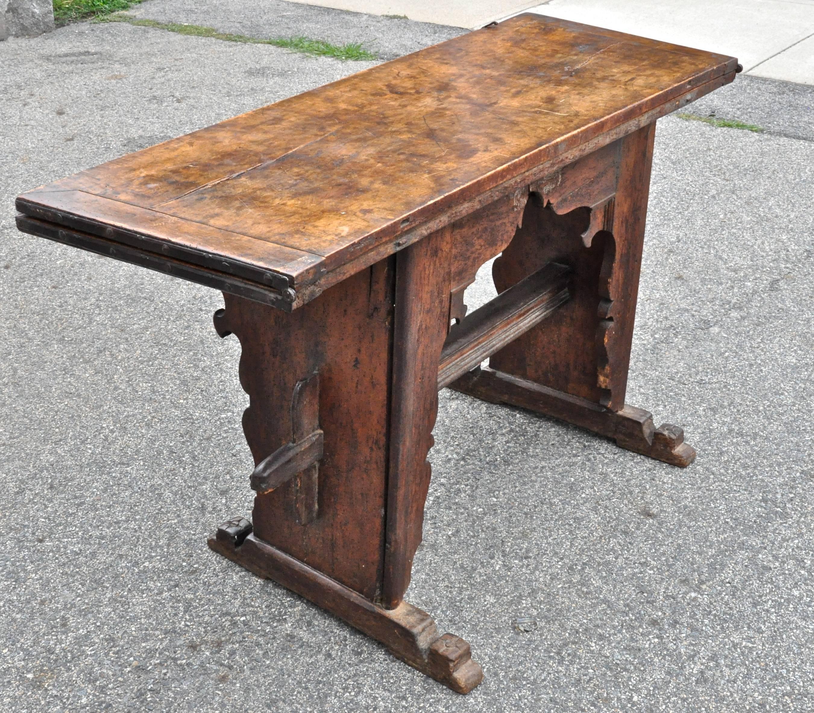 17th century Italian walnut and mixed fruitwood dough table with fold over top

Incredible originality and patina
Swing out supports hold fold over top rendering this piece useful for additional eating or work space
Dough drawer
intriguing