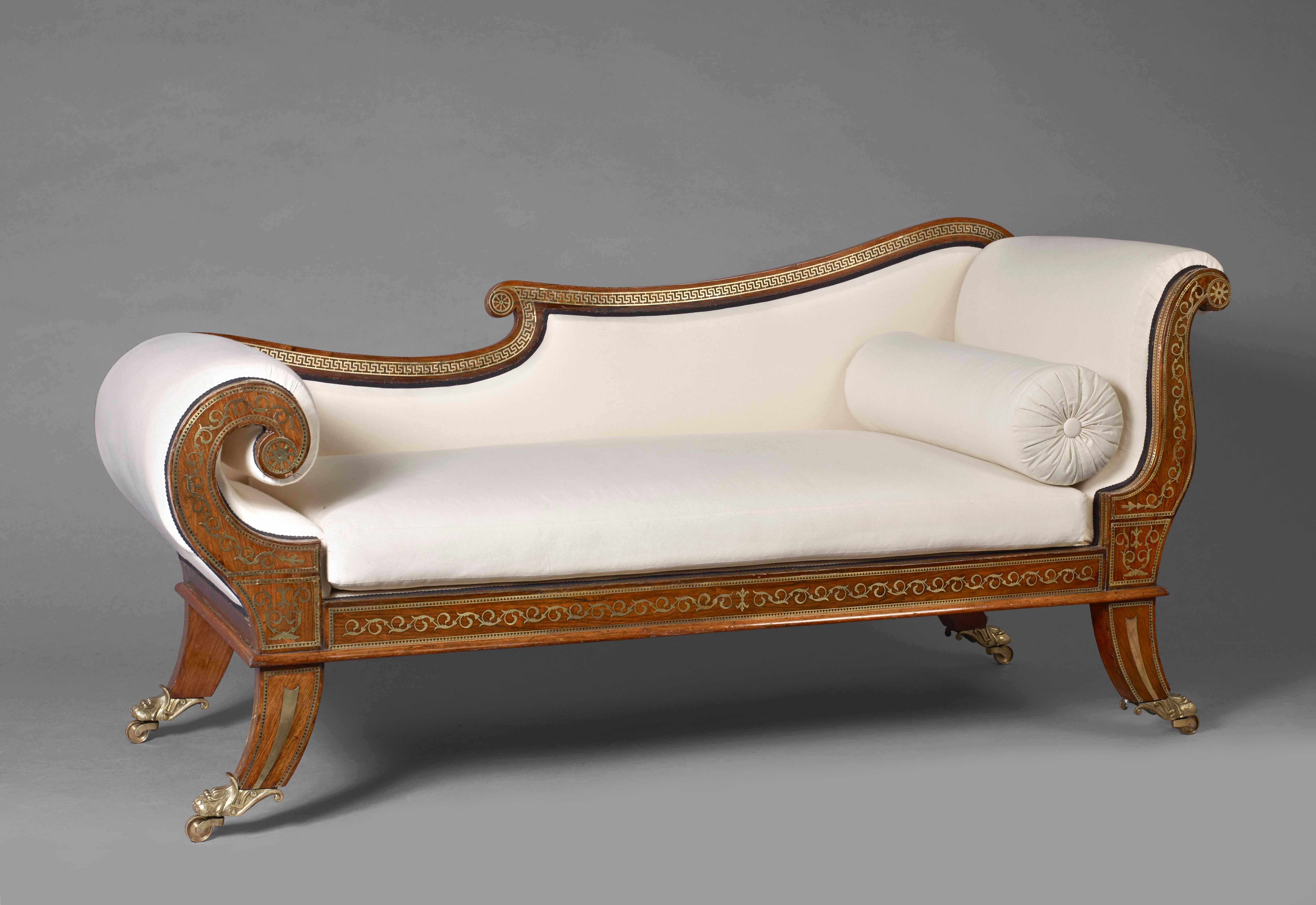 A Regency rosewood chaise longue, profusely inlaid throughout with gilt metal marquetry, the front rail and highly scrolled end supports with inlay of trailing foliage and flowers terminating in floral paterae, the back rail inlaid with Greek key