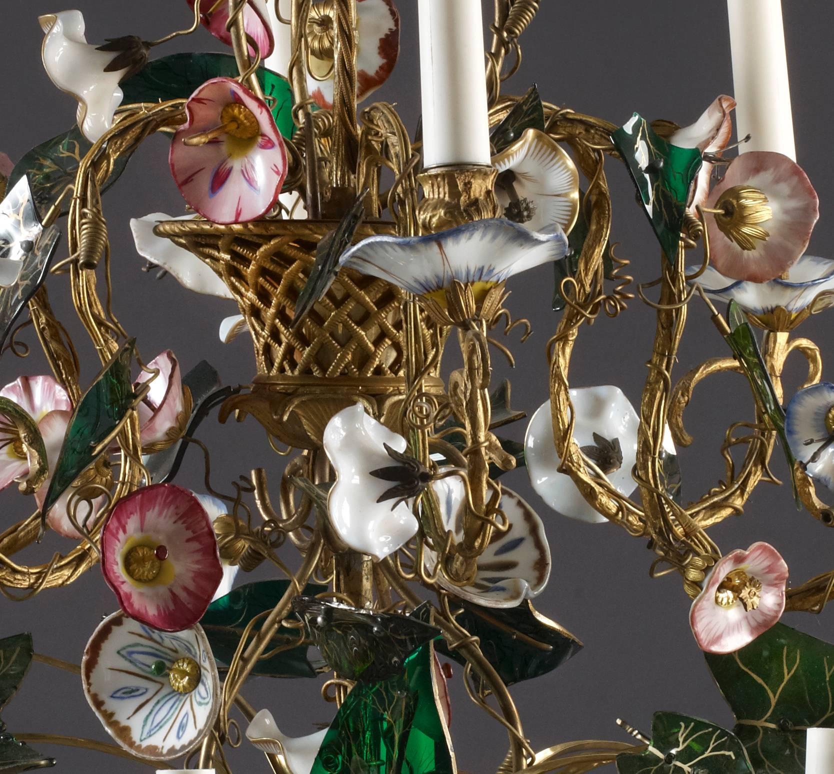 A rare two-tier Austrian chandelier with Bohemian and opaline glass flowers, the stem and arms fashioned as gilt metal vines issuing from gilded baskets, all set with boldly modeled glass vine leaves with gold veining. The convolvulus (morning