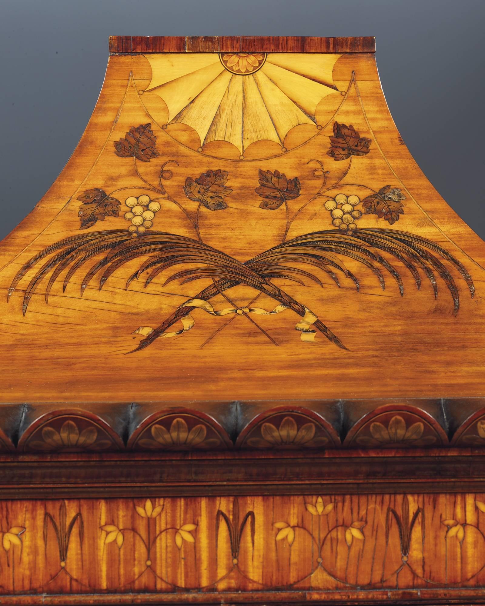An exceptional George III satinwood and marquetry cabinet on stand, attributed to Mayhew and Ince, executed in golden satinwood and inlaid with exquisite marquetry detail in a variety of exotic timbers, the pagoda top surmounted with a fan shape