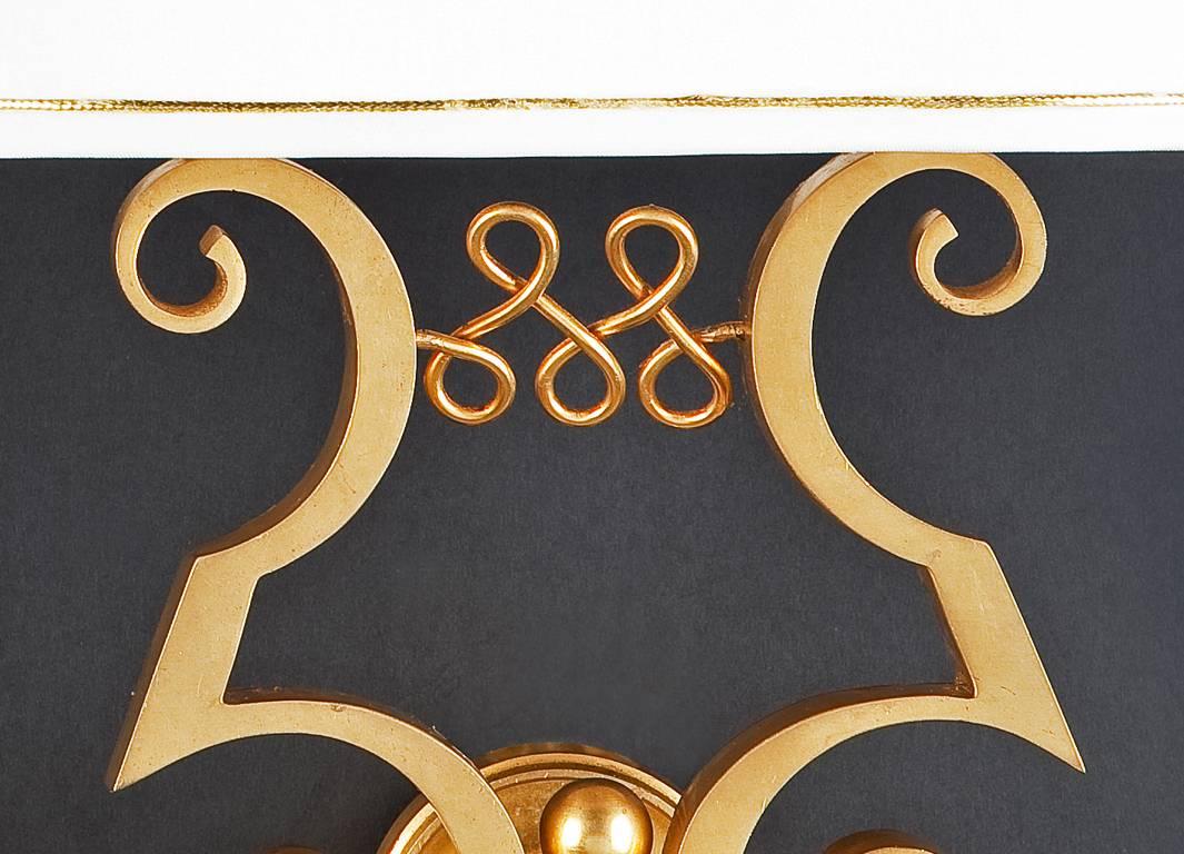 A pair of gilt bronze two-branch wall appliques, in the form of opposing, elaborate scrolls joined by a figure of eight scroll motif.

Illustrated:
Francoise Siriex, The House of Leleu, Hudson Hills Press New York 2007, p. 428.

Jules Leleu