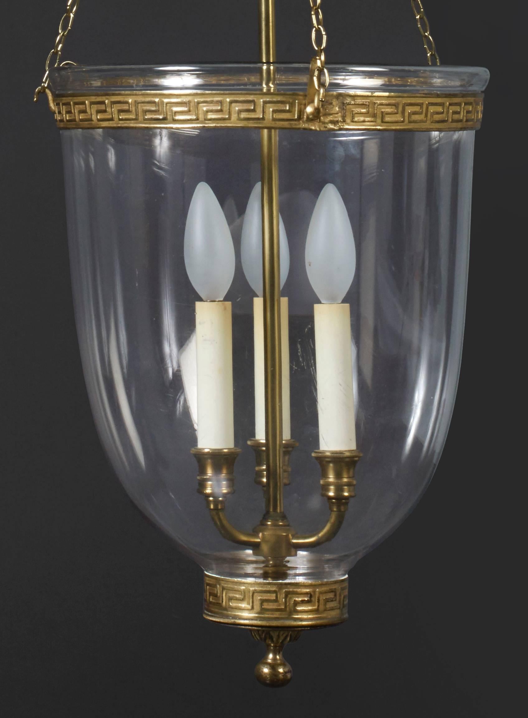 An early 19th century pendant glass hanging lantern, having a smoke cowl and suspended from a gilt lead counterweight eagle. The lantern has a candle socle at the base and a collar around the rim each enriched with low relief gilt Vitruvian scroll.