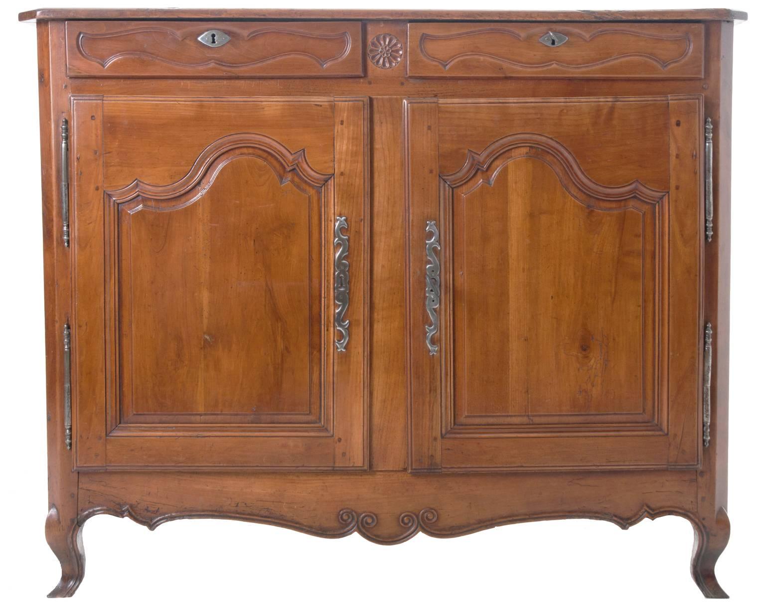 Wonderful French provincial buffet with rich dark cherry patina, you can see it's age in the detail photos all with hand cut escutcheon plates. Carved door fronts give movement to the buffet and compliment the playfully scalloped apron and cabriole