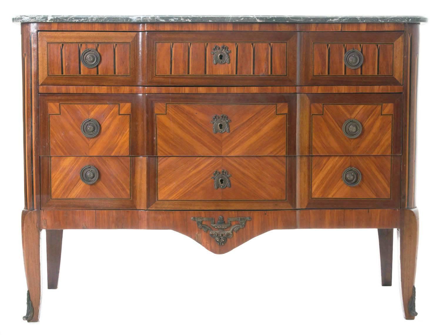 A gorgeous small commode of transitional taste with a colorful marble top, shaped to fit gracefully over the three drawer commode. Impressive and detailed wood designs are found all over this beauty, primarily in mahogany for the book matched sides
