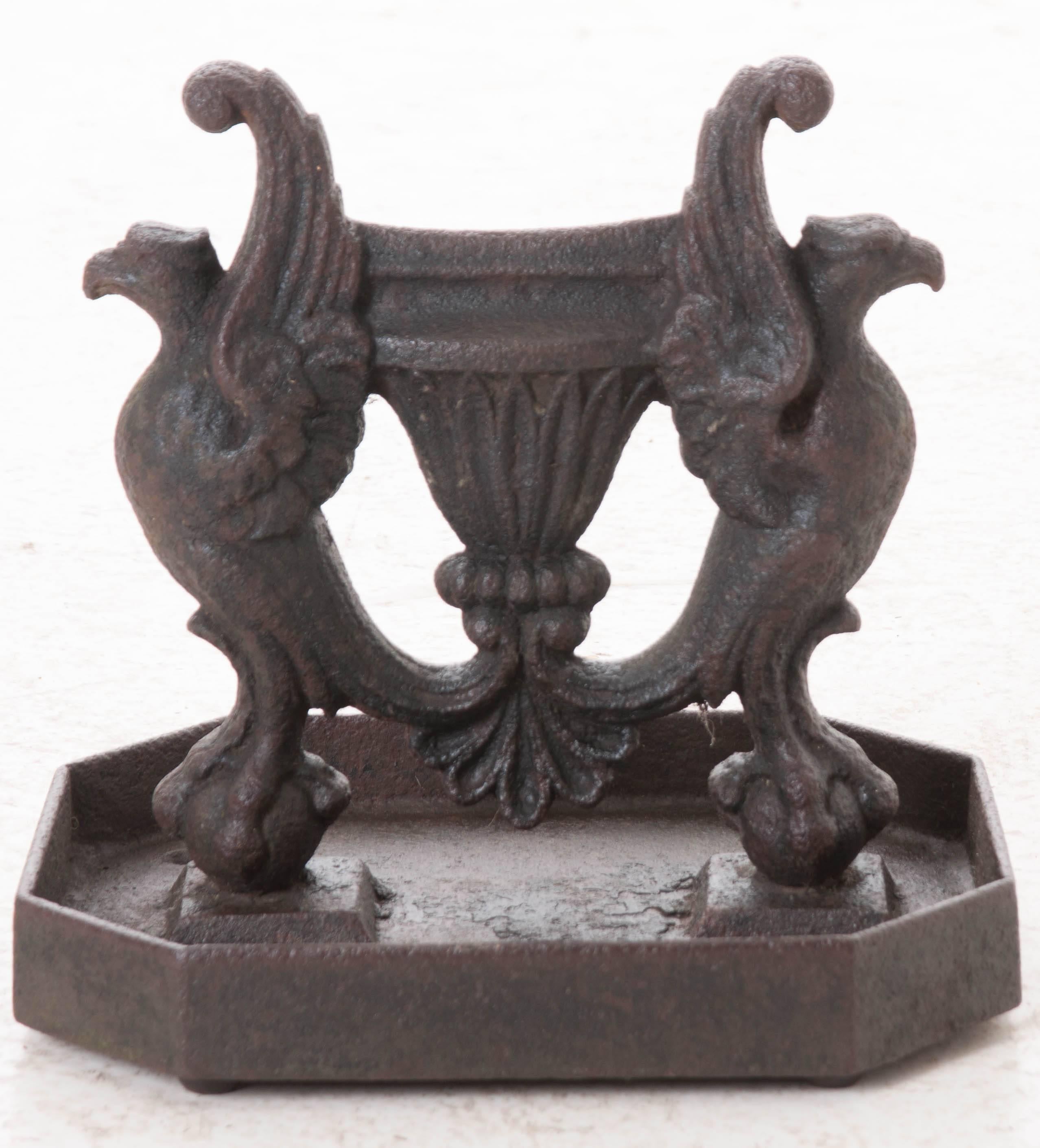 Boot scrapers, as their name suggests, were placed outside the entrance of a building and used to remove mud and debris from a person's boots prior to entry. This piece is made of solid cast iron, is adorned with two regal phoenixes and has very