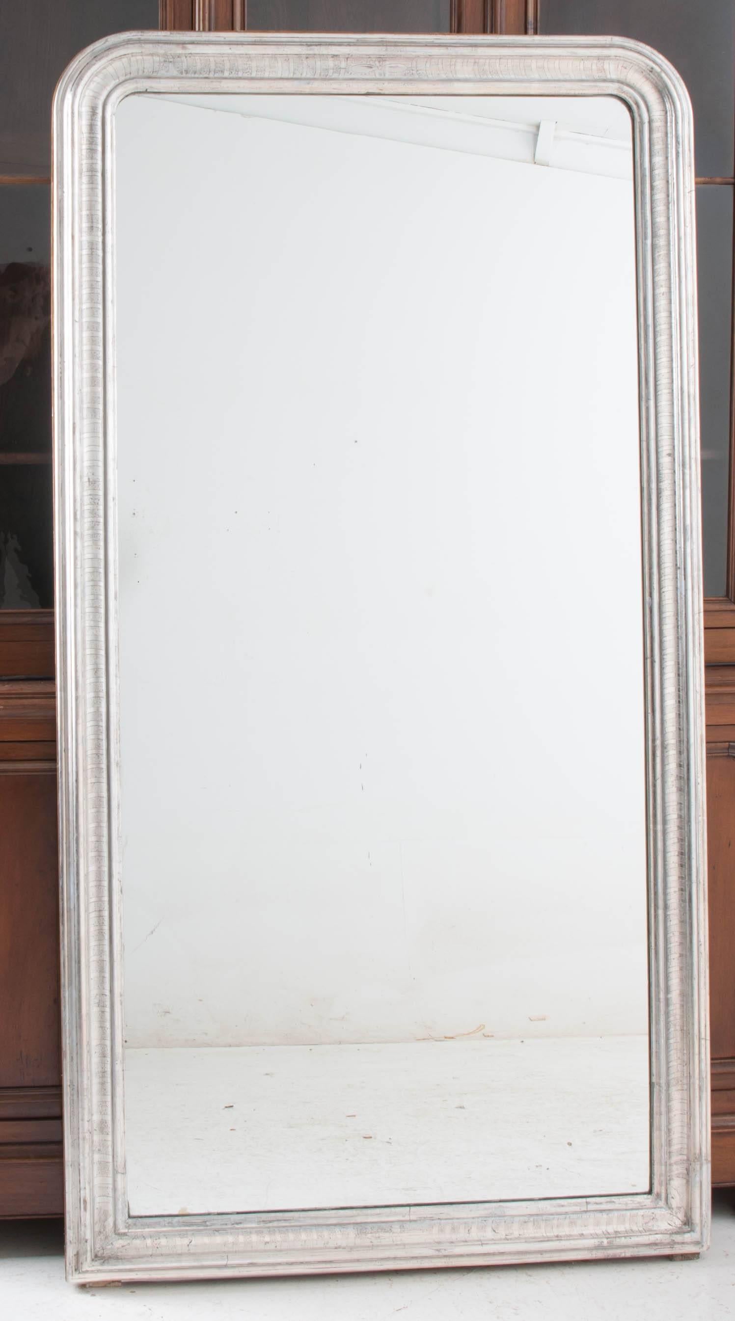 This spectacular Louis Philippe silver gilt mirror is tall enough to make a fabulous floor mirror and would also look wonderful hung on the wall. This mirror bears a striped motif and has new glass.