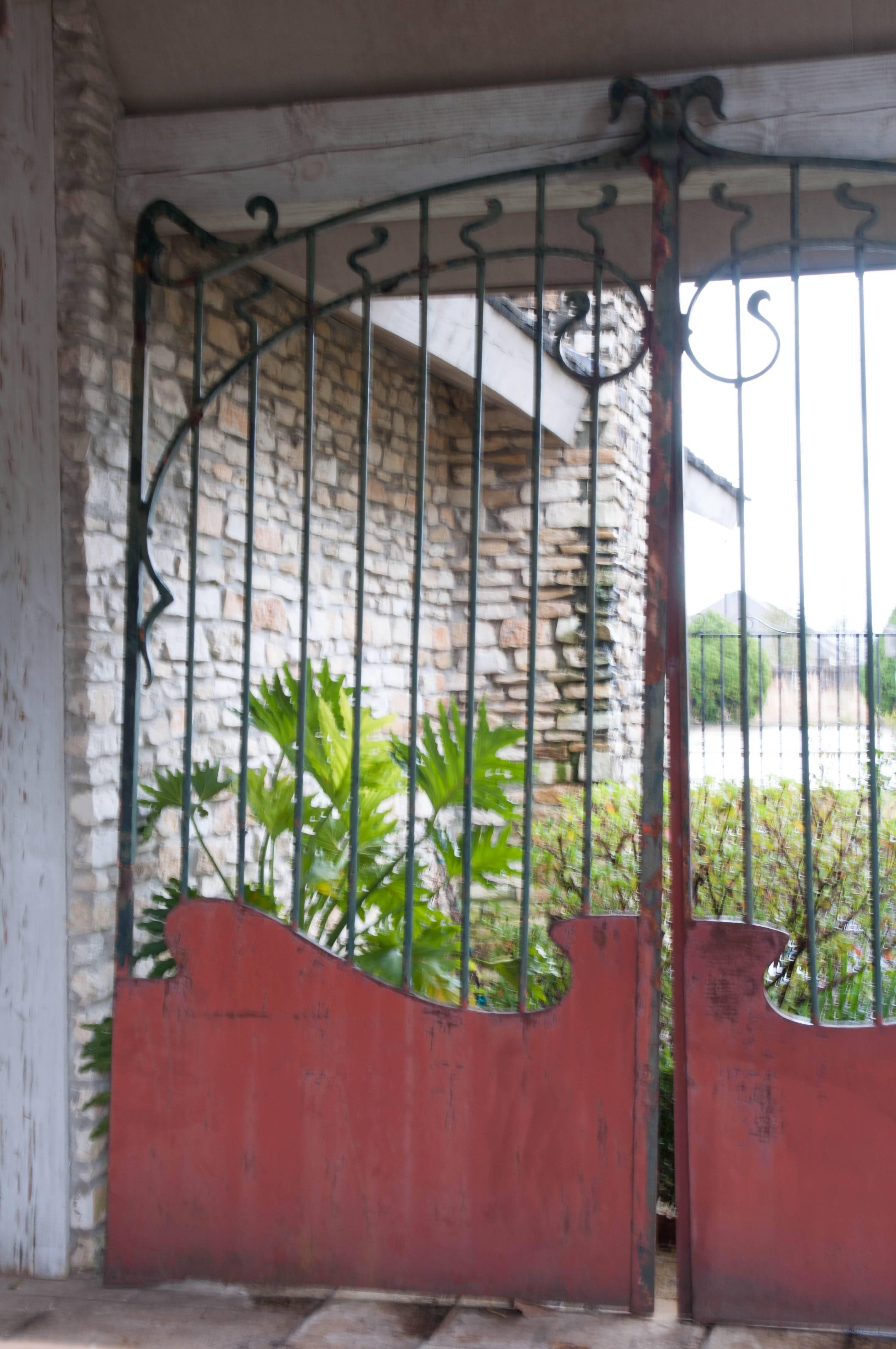 A magnificent French Art Nouveau forged iron gate from 1900. The massive iron doors are styled with sinuous curves and meandering swirls of forged iron, one of the fundamental characteristics of the Art Nouveau movement.