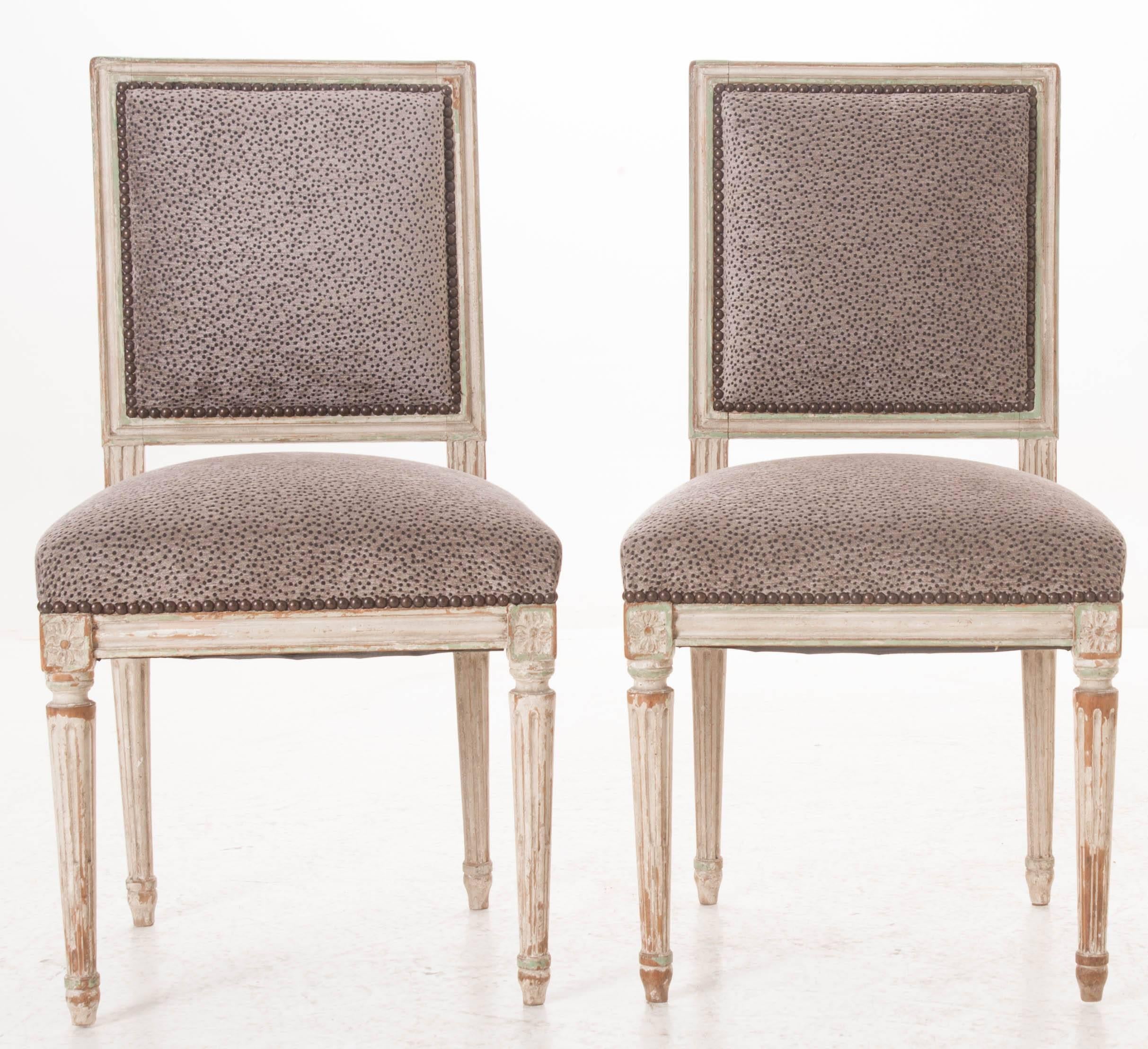 A newly upholstered pair of exceptional painted Louis XVI side chairs from 19th century, France. These lovely square back chairs have great, clean lines and still wear their original paint. Their antique painted finish has acquired extraordinary