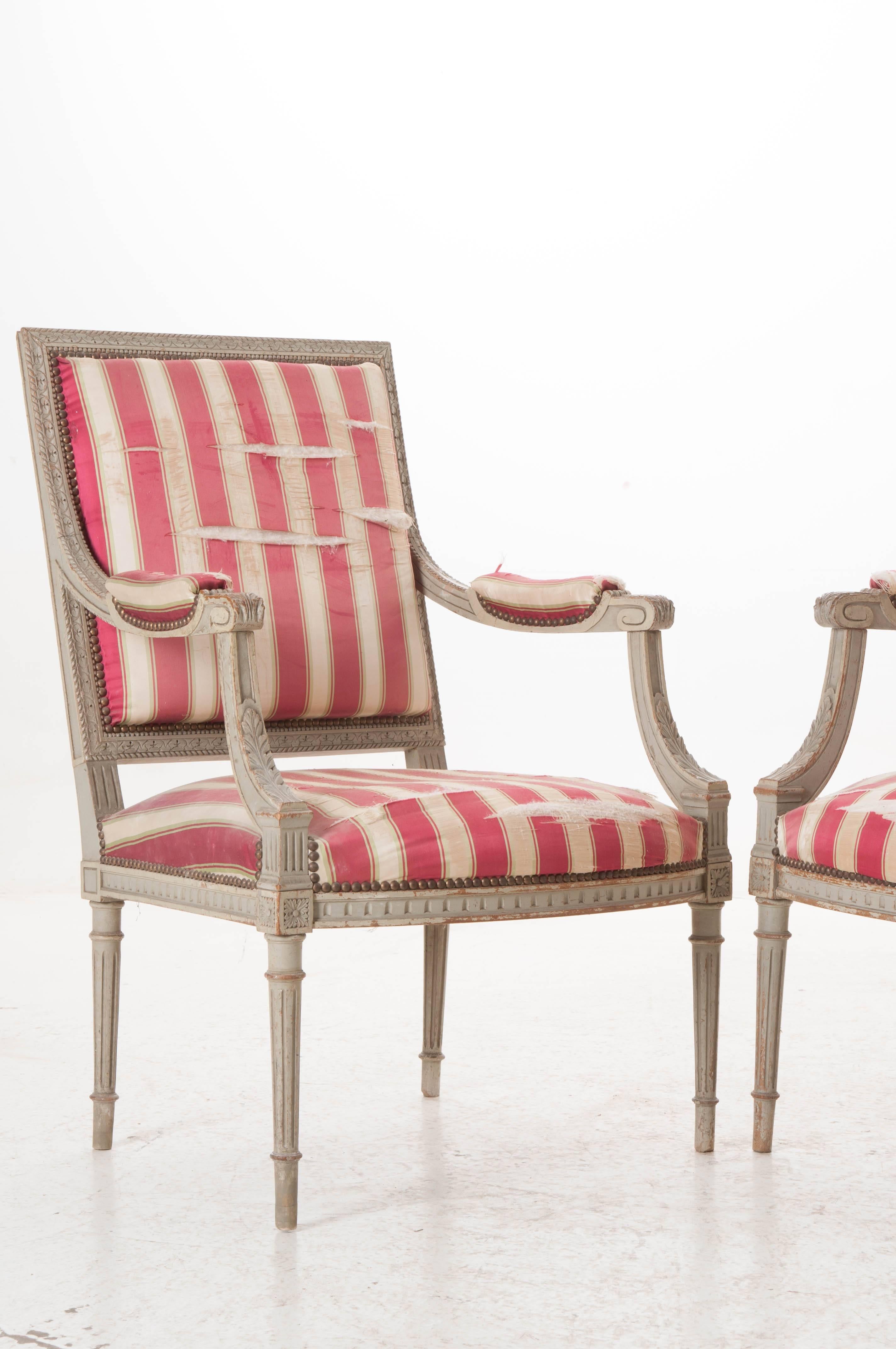An incredible pair of French Louis XVI style Fauteuils from 1870. The pair is in need of reupholstering, but have exceptional frames that are decorated with fabulous carvings all-over. The square backs are surrounded by carved pearl and twisted