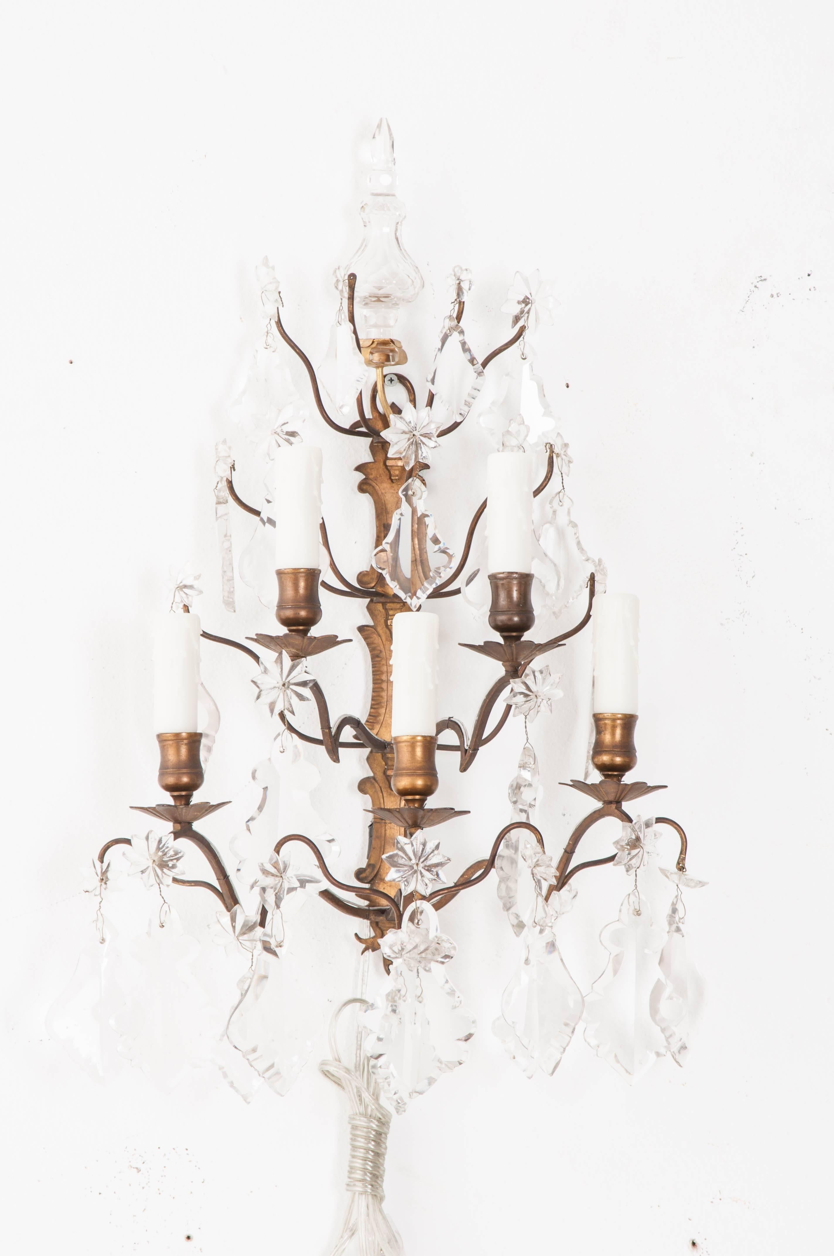 A fabulous pair of five light brass and crystal sconces from 19th century France. Each sconce is decorated with beautiful crystals suspended from the antique brass frame. These fixtures have been cleaned and wired for U.S.