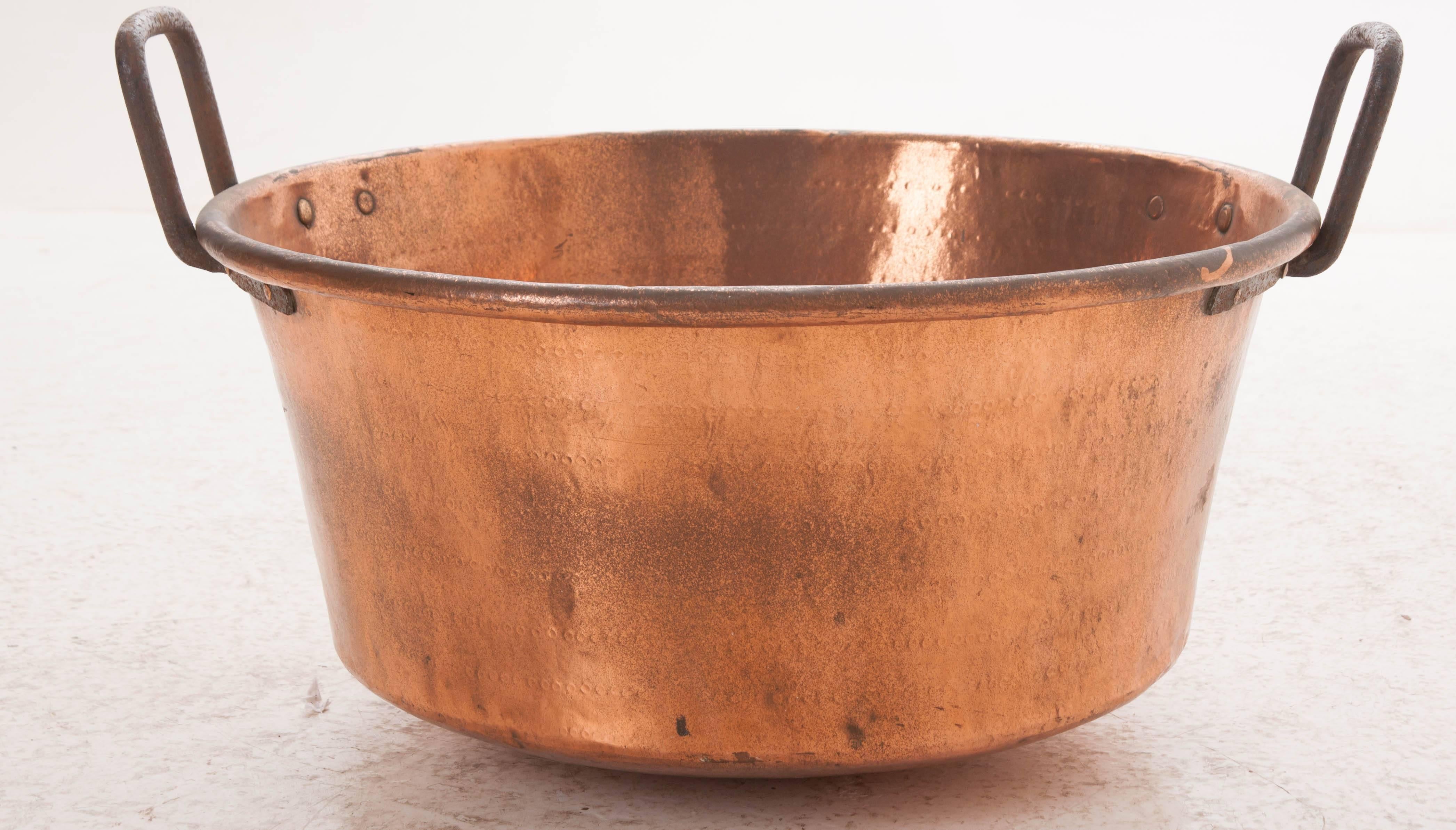 This massive 19th century copper pot is known as a jam pan. Used in the production of fine jambs and jellies, these large vessels often have hammered interiors and large iron handles and would be used to cook down the fruit and sugar. Today, this