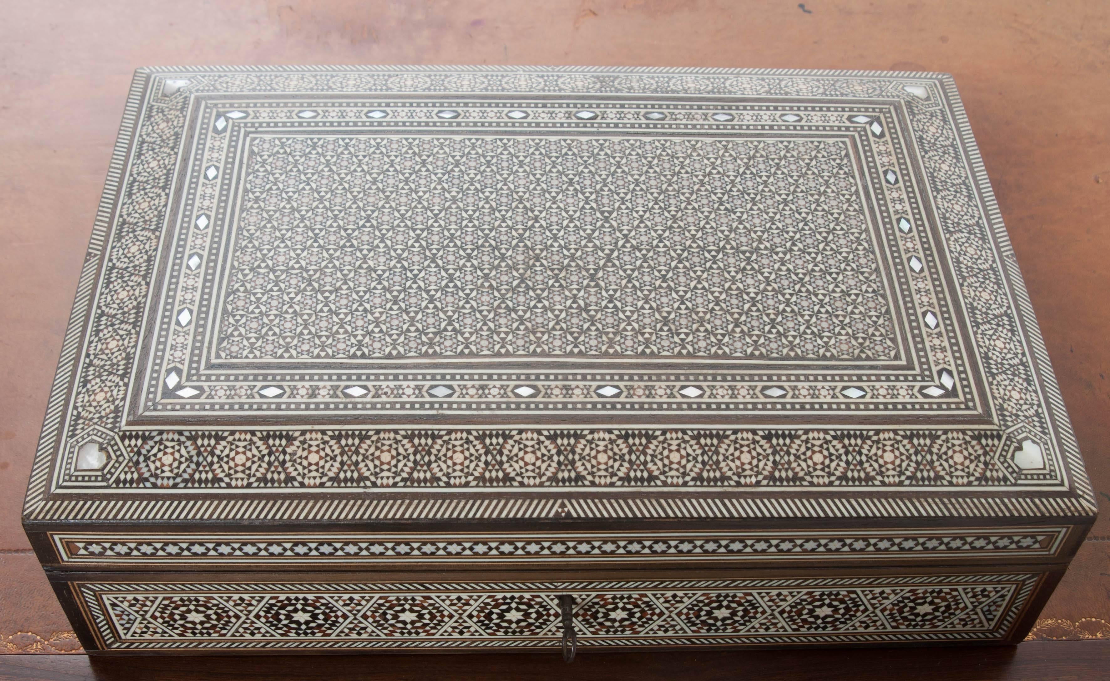 Intricately inlaid bone, mother-of-pearl, satinwood and rosewood adorn nearly every square inch of this exquisite 19th century Syrian inlay box. Six pointed stars, diamonds, and a continuous hexagonal motif design have been painstakingly arranged