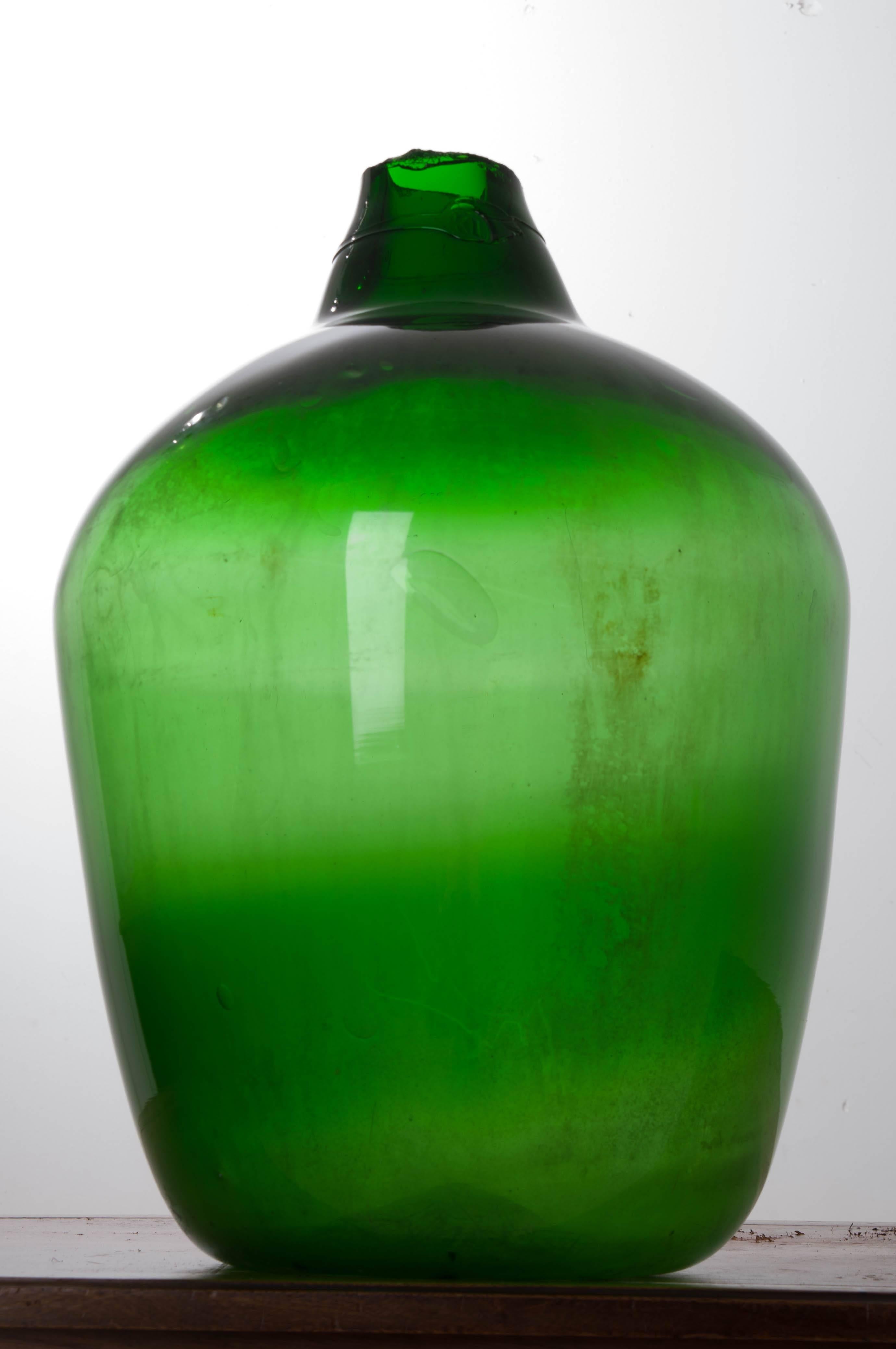 This large, green wine keg, also known as a demijohn or carboy, remains intact after almost 150 years. This vessel has a vivid emerald green color and high shoulder, setting it apart from other wine kegs. Still in wonderful condition, this piece