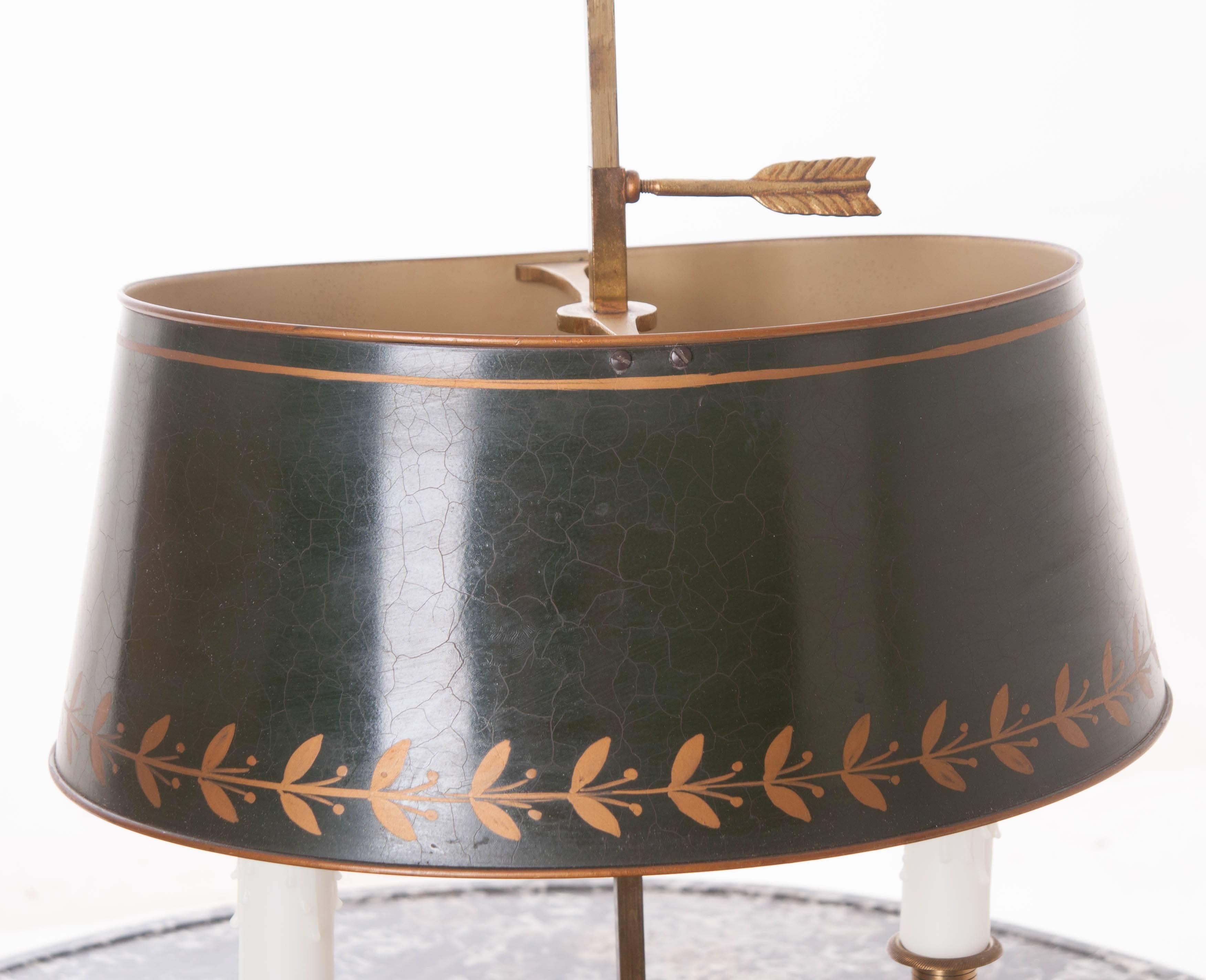 A beautifully designed French Bouillotte lamp with its original green and gold painted tole shade. Bouillotte is a card game, popular in France during the 18th and 19th centuries. For light, they would use a bouillotte lamp. This lamp is brass with