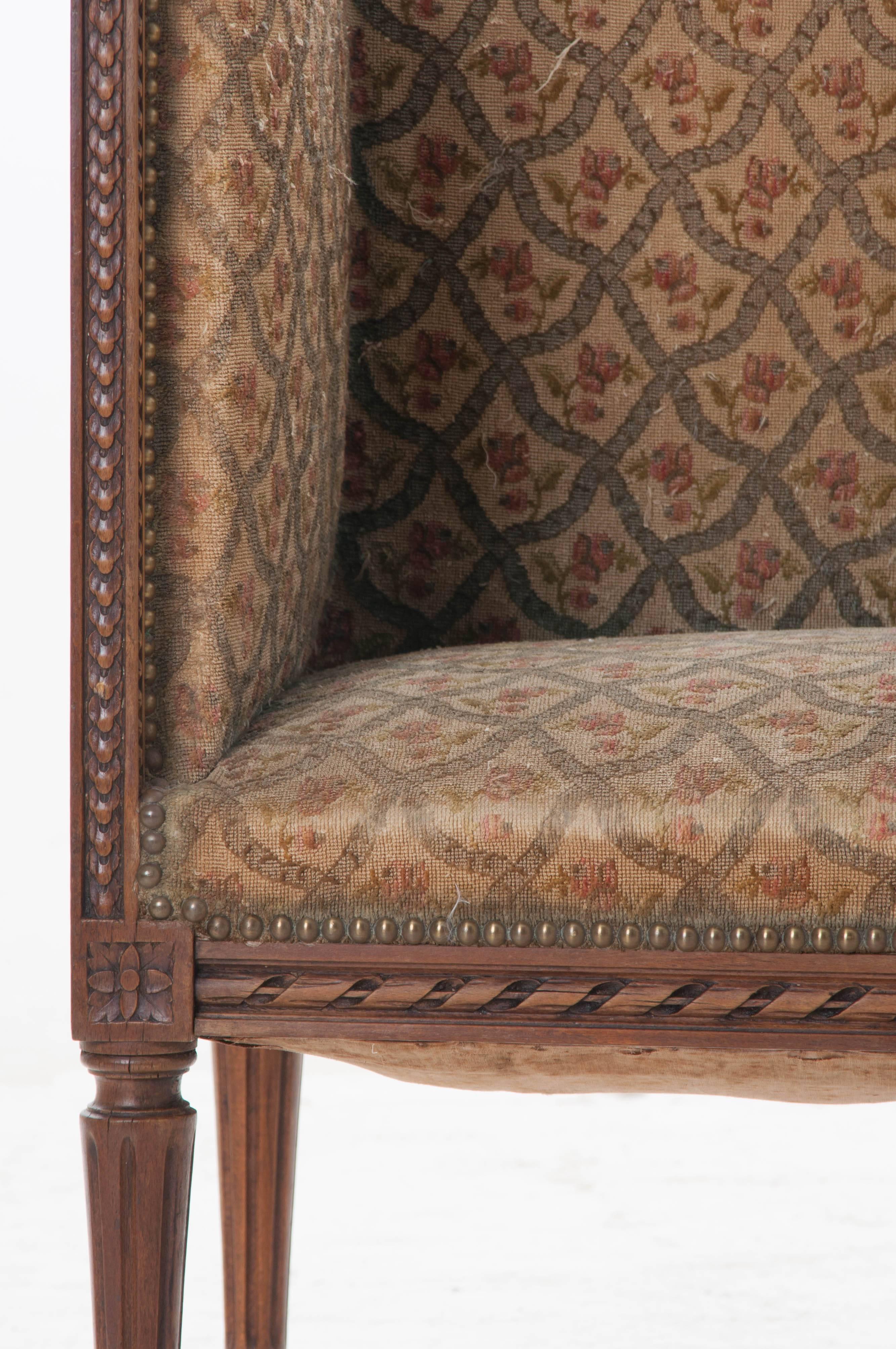 A wonderfully sized Louis XVI period walnut settee from 18th century, France. This exceptional piece has an unusual, high, straight back and sides that give it a distinct style that is impossible not to fall in love with. The walnut frame boasts