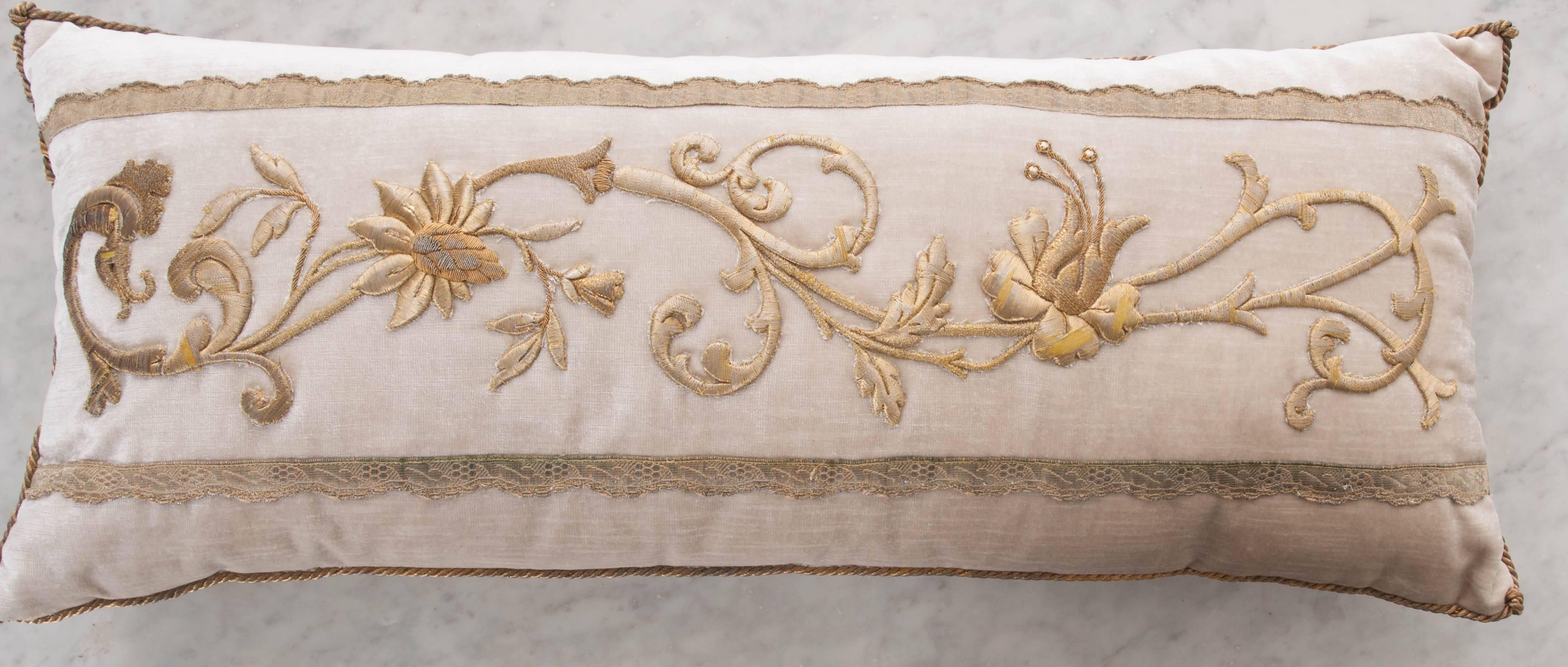 Antique European raised gold metallic embroidery of vining flowers and scrollwork with antique semi serpentine gold metallic galon on oyster velvet. Hand trimmed with gold metallic cording knotted in the corners.