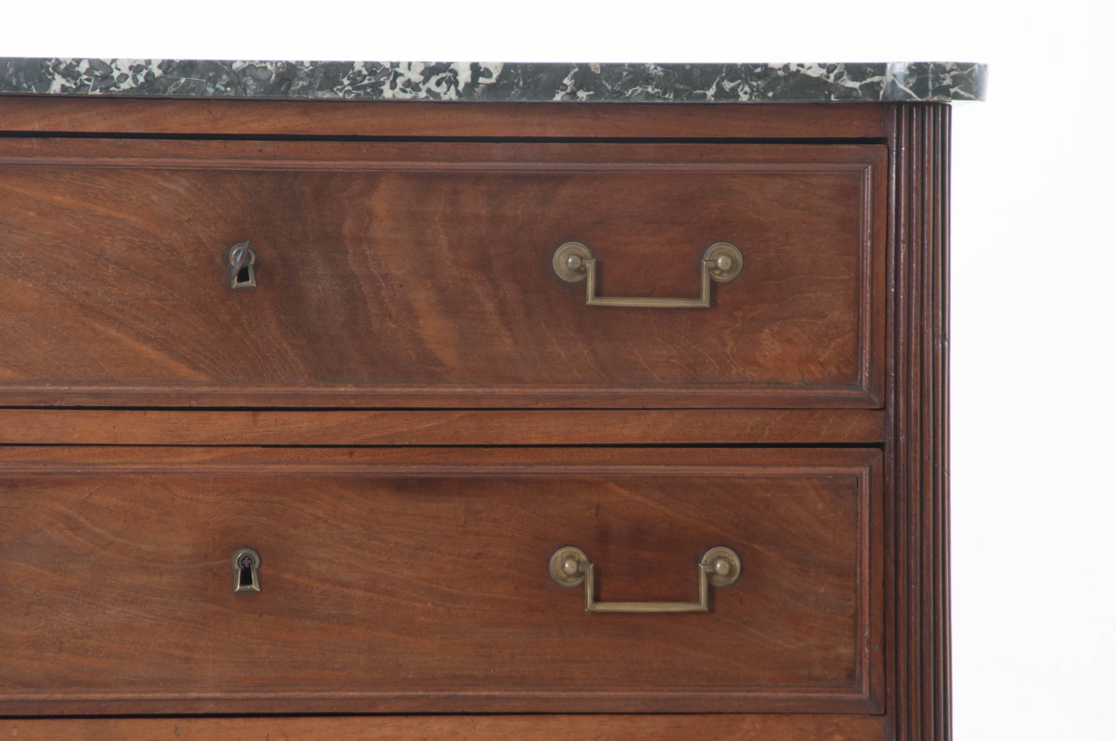 A stately three-drawer transitional walnut commode with original marble top from 19th century, France. The grey marble top is original, in great antique condition, and shaped to fit this chest perfectly. The three drawers contain working locks and