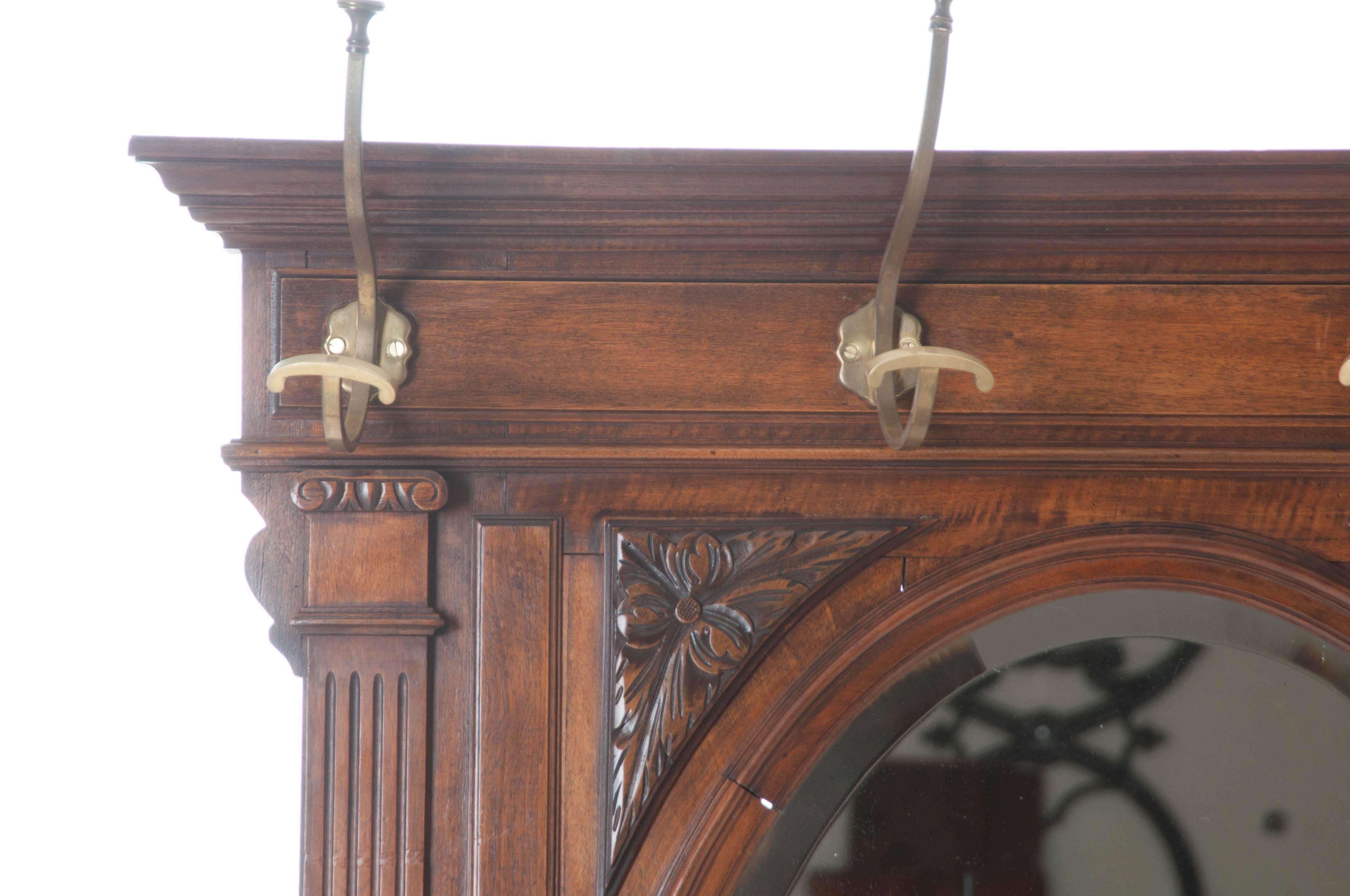 A gorgeous 19th century, wonderfully carved, French walnut hall tree. Ten solid brass hooks provide places to hang your hats, coats, and scarves when coming in from the weather. Additional curved brass hardware allows umbrellas to be stored upright,