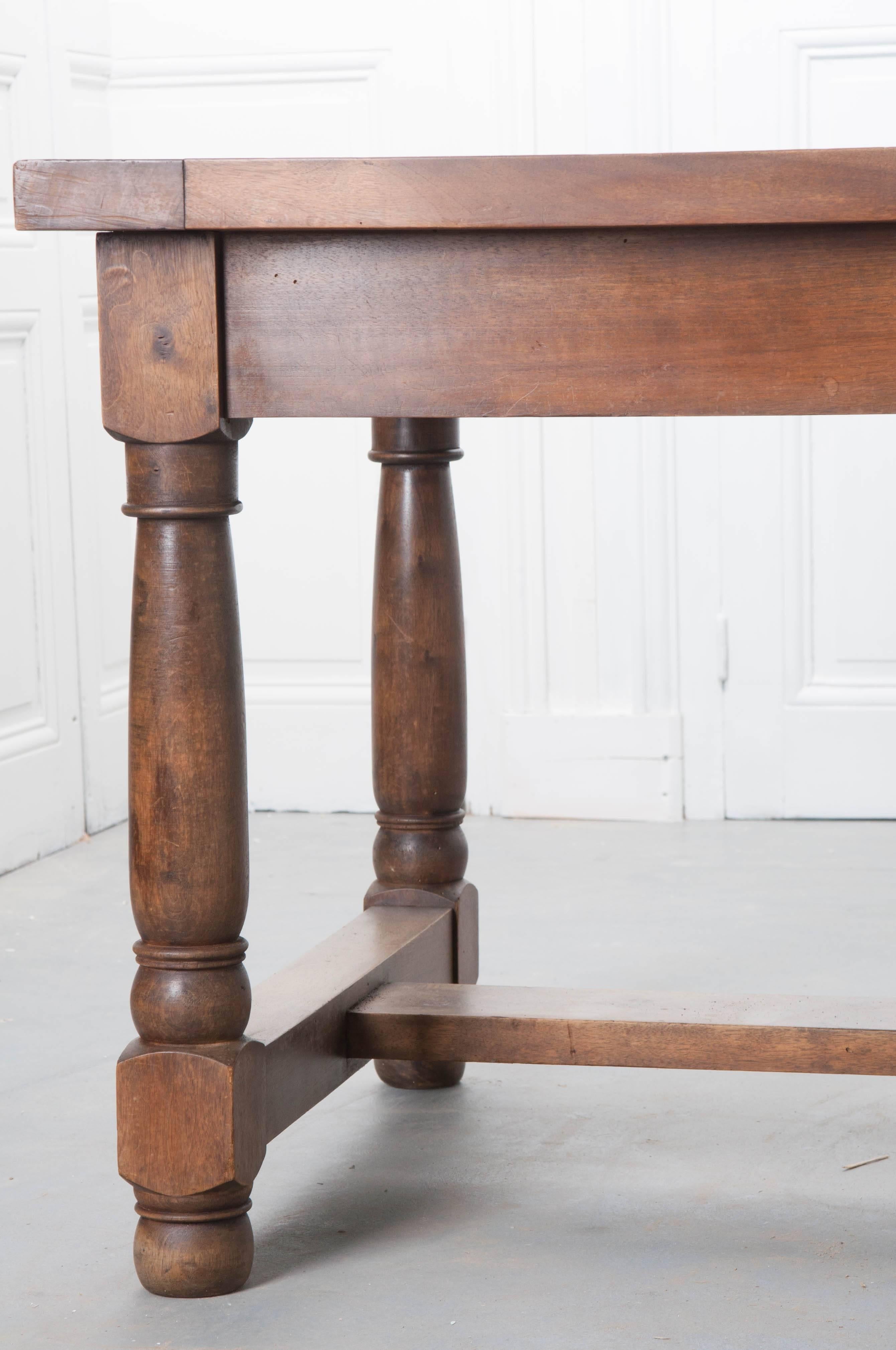A thick, solid oak 19th century farm table from Southern France. Impeccable patina envelops the beautifully toned and aged, sturdy walnut. Three drawers are located in the apron, providing out of sight storage. The drawers all have antique scrolled