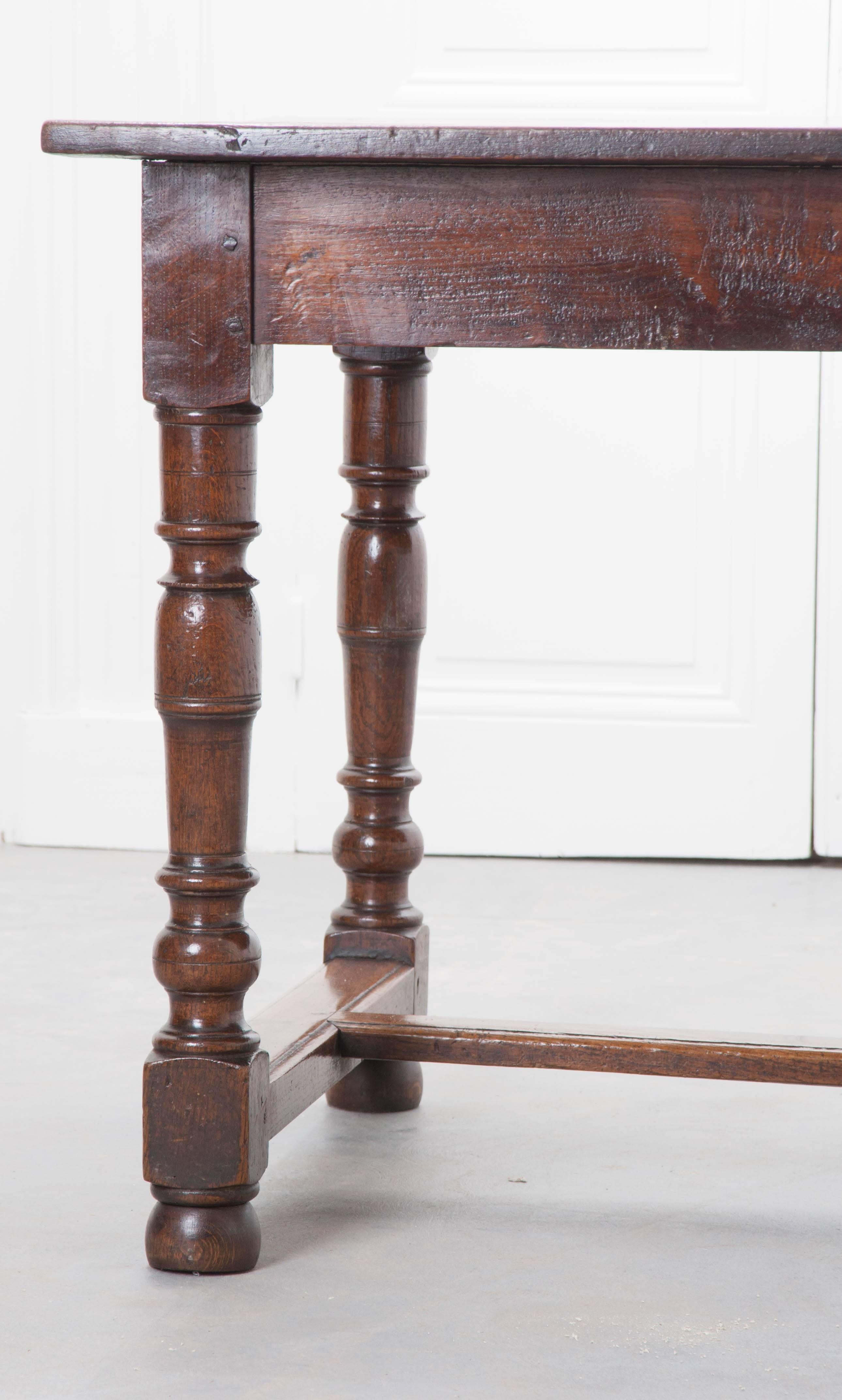 A remarkable oak farmhouse table from early 19th century, France. This beautiful table has been used and loved for close to two hundred years, imparting a patina that you will only find with French waxed antiques. The oak boards that form the