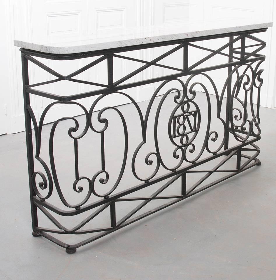 Once an iron balcony surround, this 19th century French iron piece has been made into an exceptional marble top console. The stone top is new, with a wonderful natural colored marble that will work anywhere. Wonderful scrolled and geometric iron