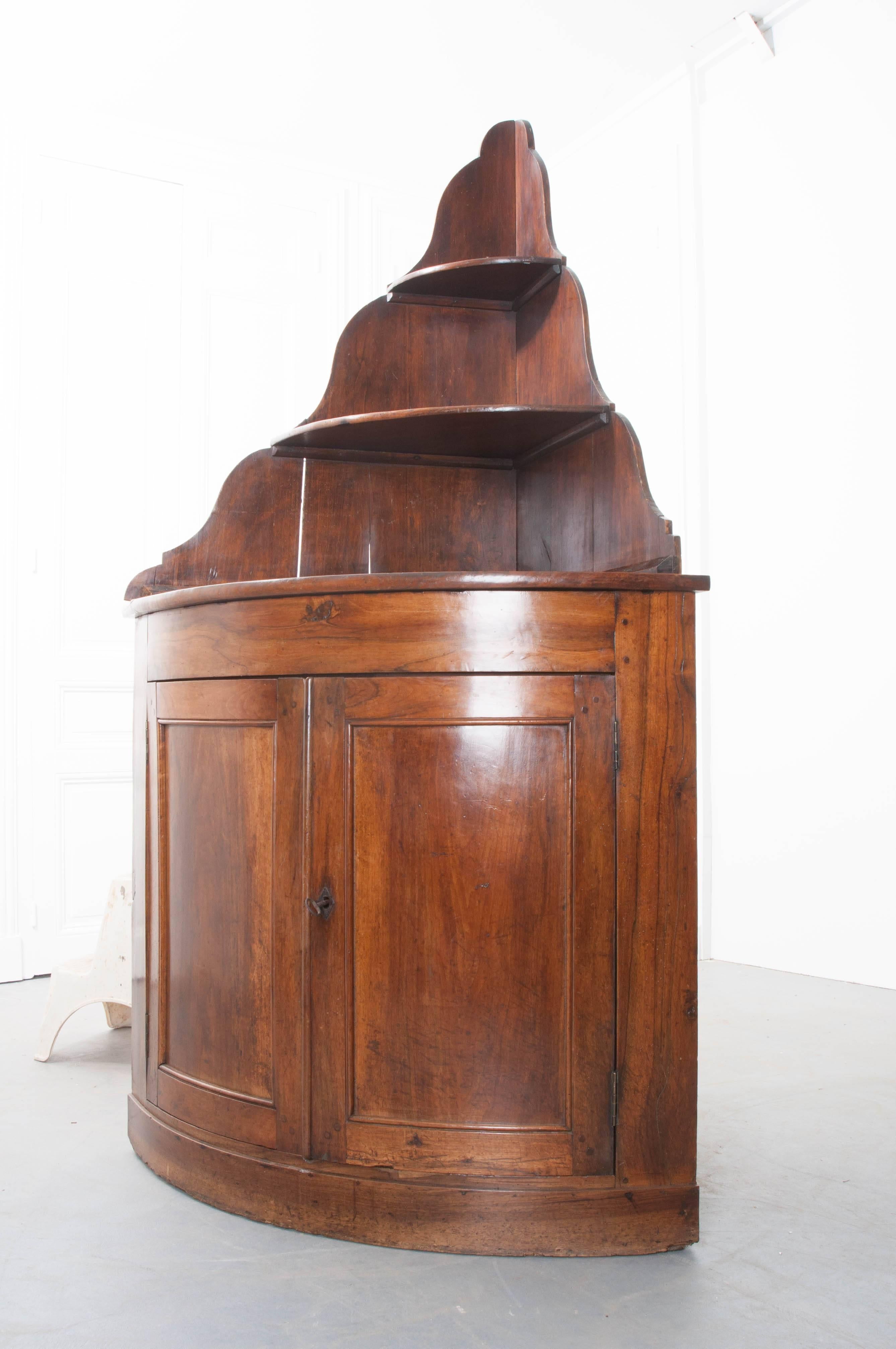 A marvelous solid walnut corner cabinet from 19th century, France. Often used as liqueur cabinets, these wonderful pieces are a great utilization of space. Today, it would make a wonderful bar or server in a dining area. The shaped back supports two
