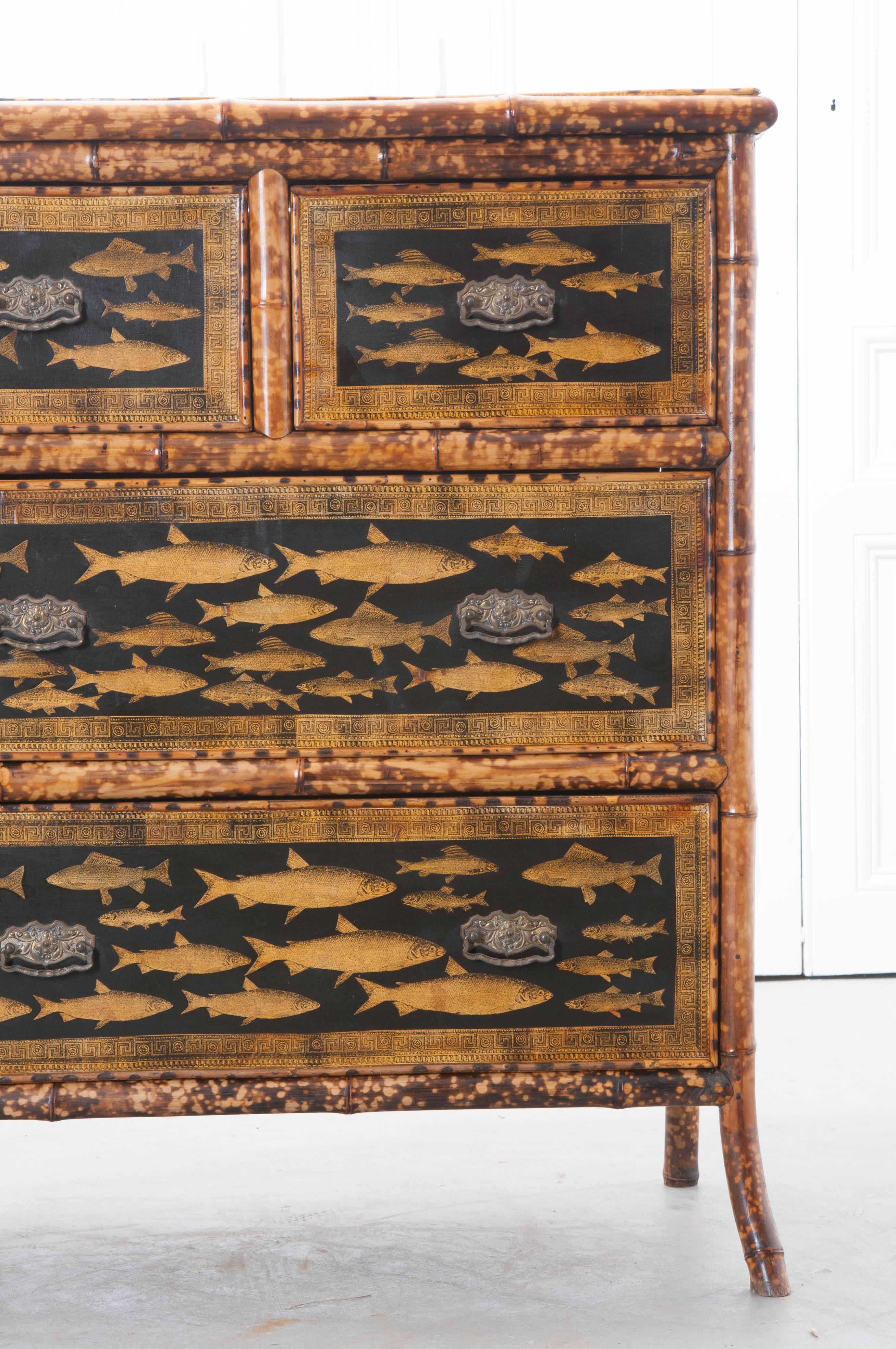 This great little Victorian bamboo four-drawer chest of drawers comes to us from 19th century, England. The antique chest has been more recently decoupaged with a wonderful collection of gold colored fish. In addition to decoupaged fish, the drawer