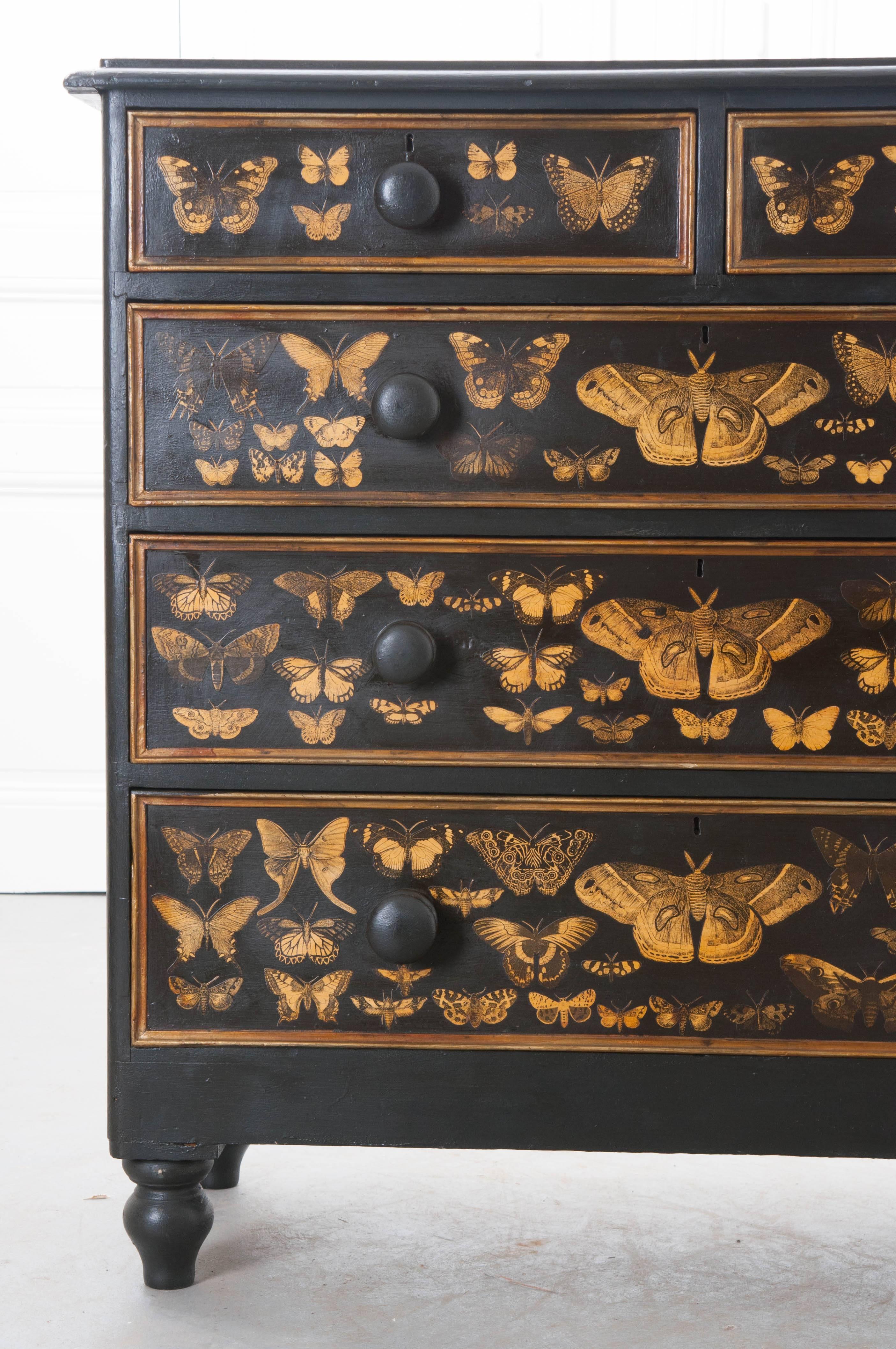 A spectacular five drawer Victorian painted chest of drawers from 19th century England, that has more recently had beautiful gold moths decoupaged onto the piece. The chest has two smaller top drawers with three larger drawers beneath that are