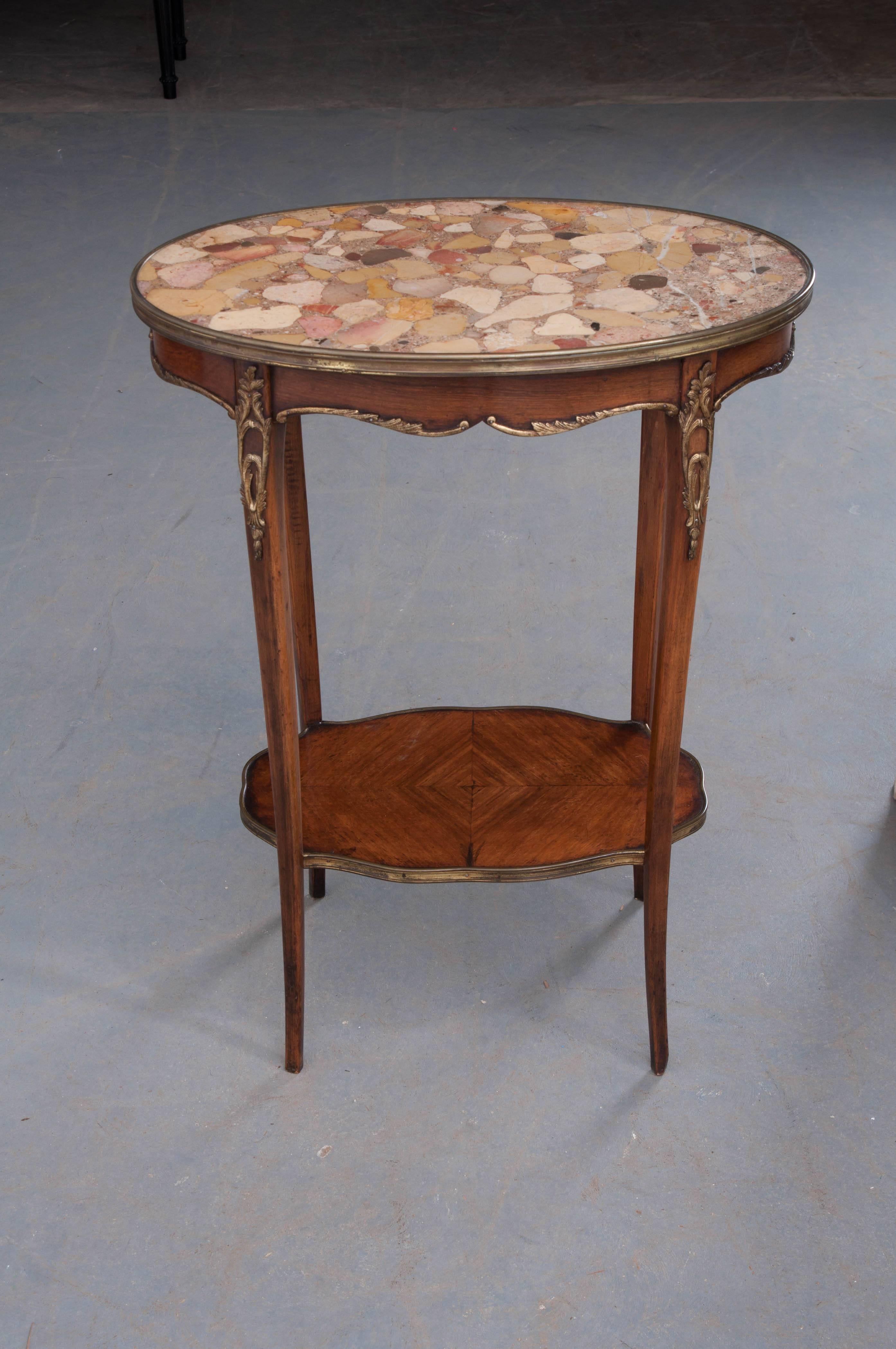 A darling mahogany Louis XV style table, with marble top, from the end of the 19th century, France. The table is topped with a beautiful oval piece of brèche d'Alep marble that is inset and secured with a band of brass. The shaped mahogany apron as