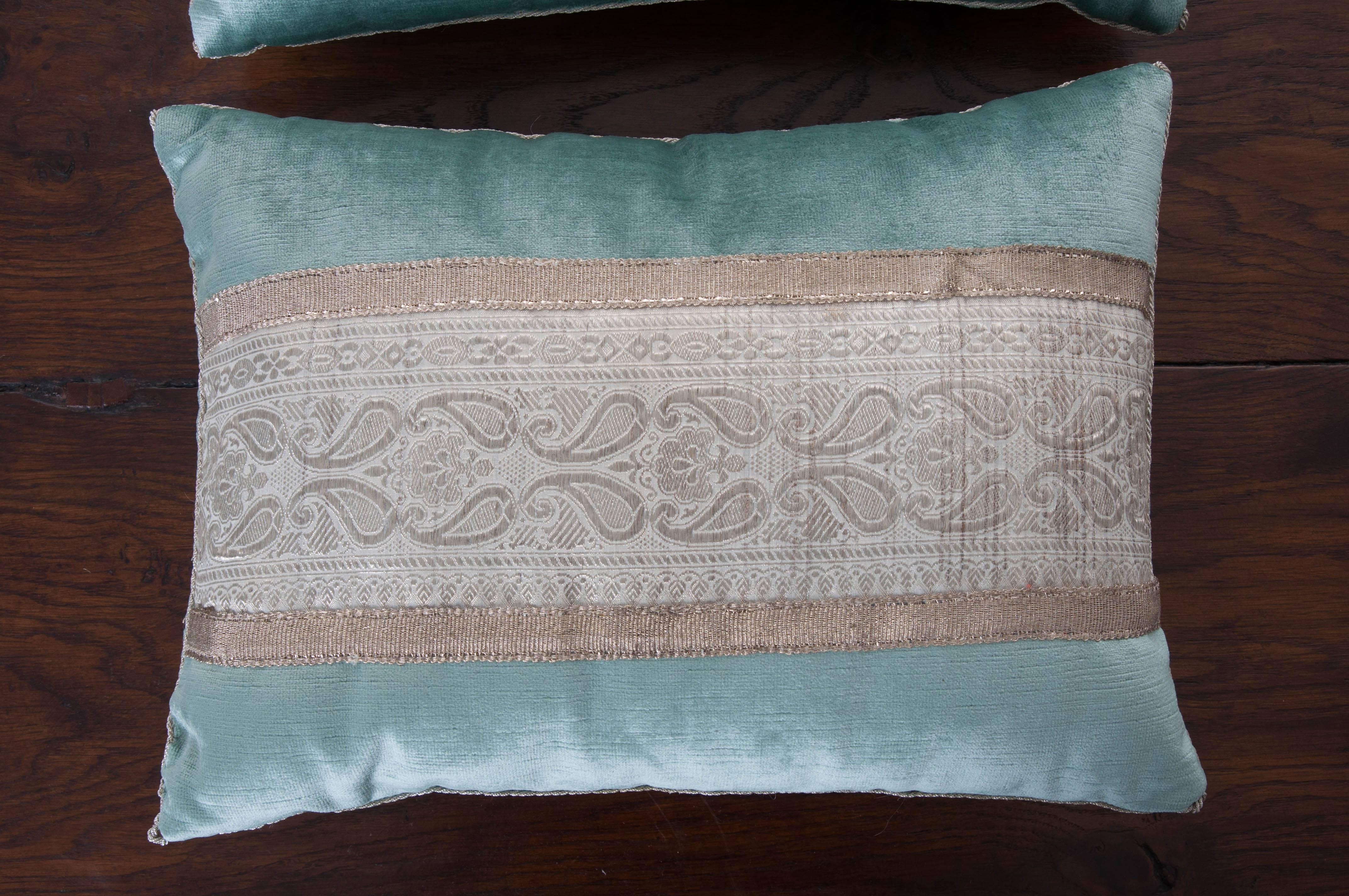 Vintage Sari border from India in silver, bordered by antique silver metallic galon on aqua velvet. Hand trimmed with tiny silver metallic cording, knotted in the corners. Down filled. 

 