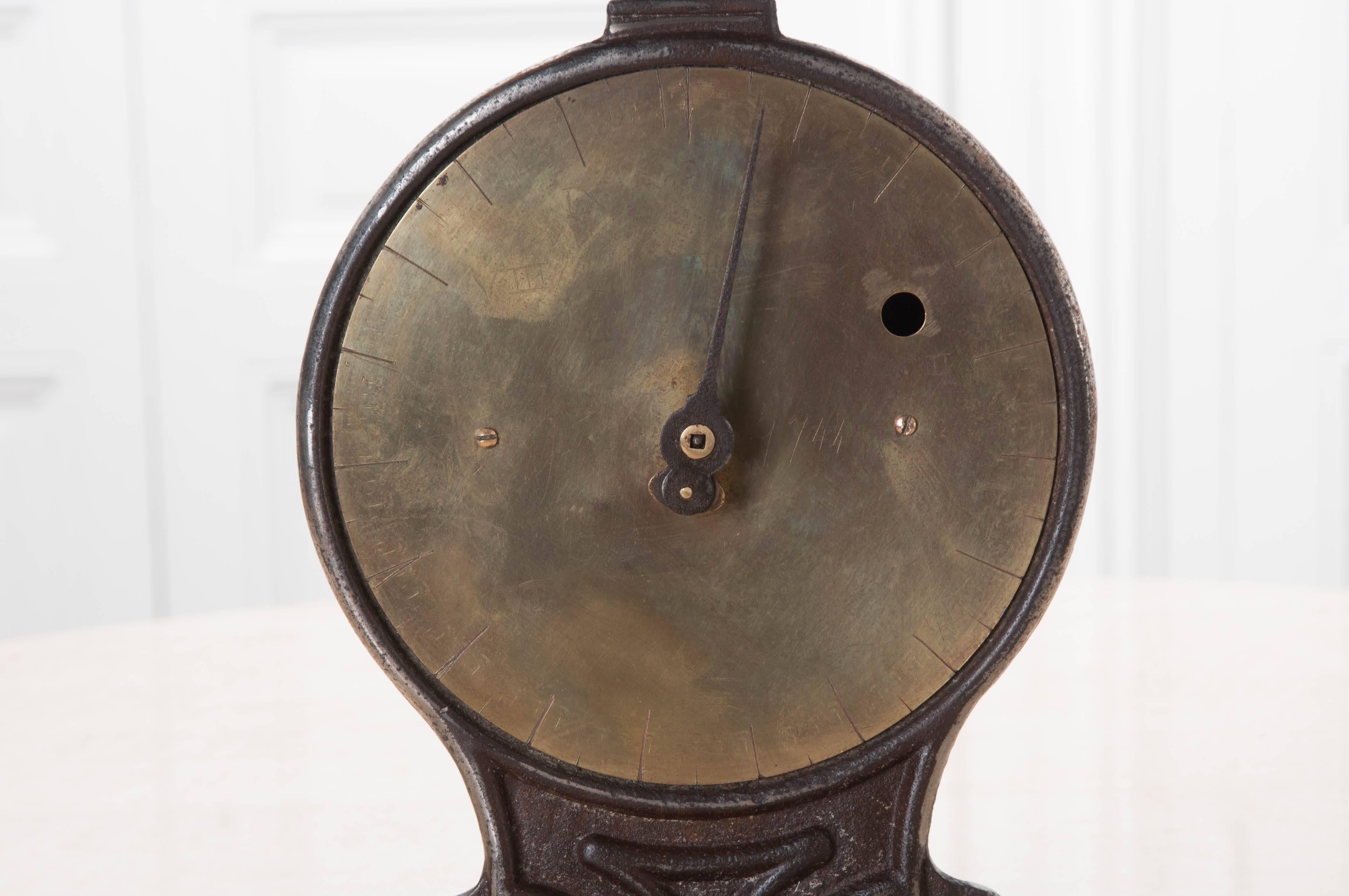 An English scale from the 1890s. This scale has a large, round, brass face with its dial in the centre. The cast iron base is heavy, with stylized details adding to its allure. Simply add product to the hammered metal tray, and that's how easy it is