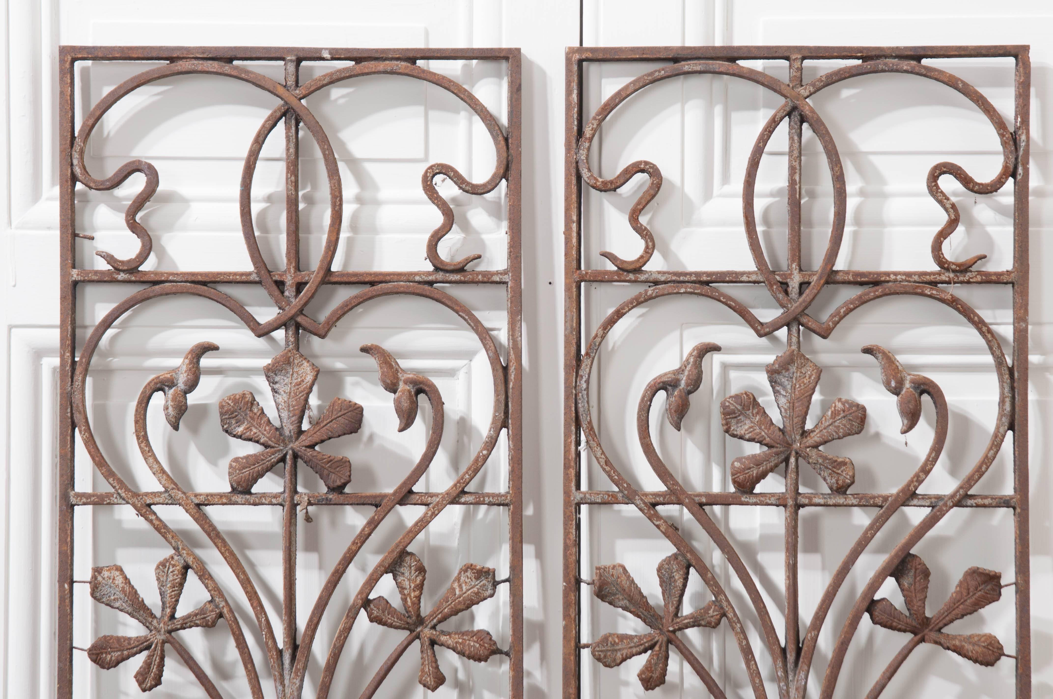 Pair of fabulous period Art Nouveau wrought iron panels from the early part of the 20th century, France. These wonderful panels make great wall decor both inside and out. Hallmark twists and curves mix with foliate and floral motifs to create these