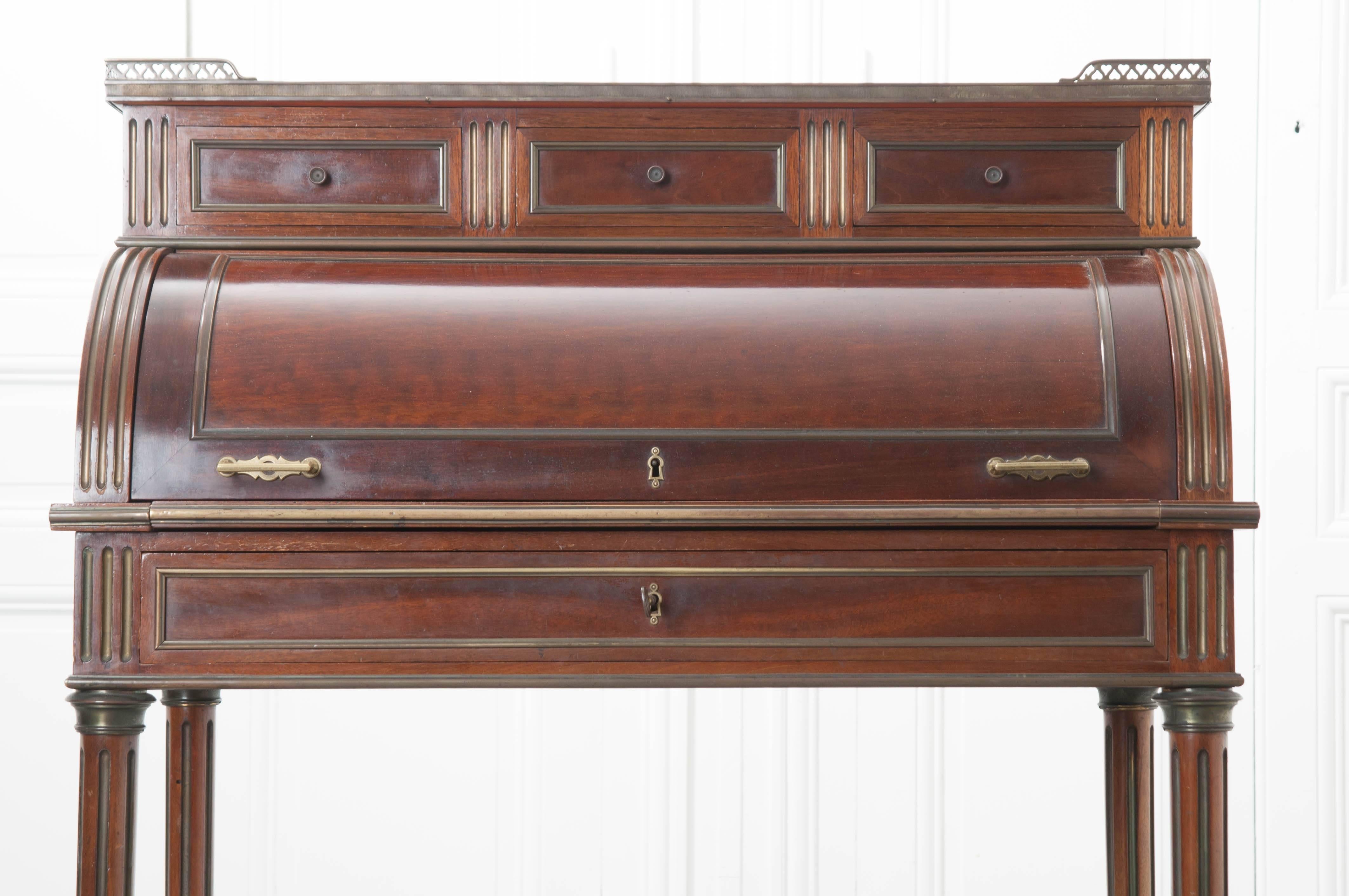 A remarkable roll top lady's desk, done in mahogany, from 19th century, France. The desk has a rectangular galleried marble top, under which are three short drawers that will only open if the cylinder top is open. This roll top opens to reveal an