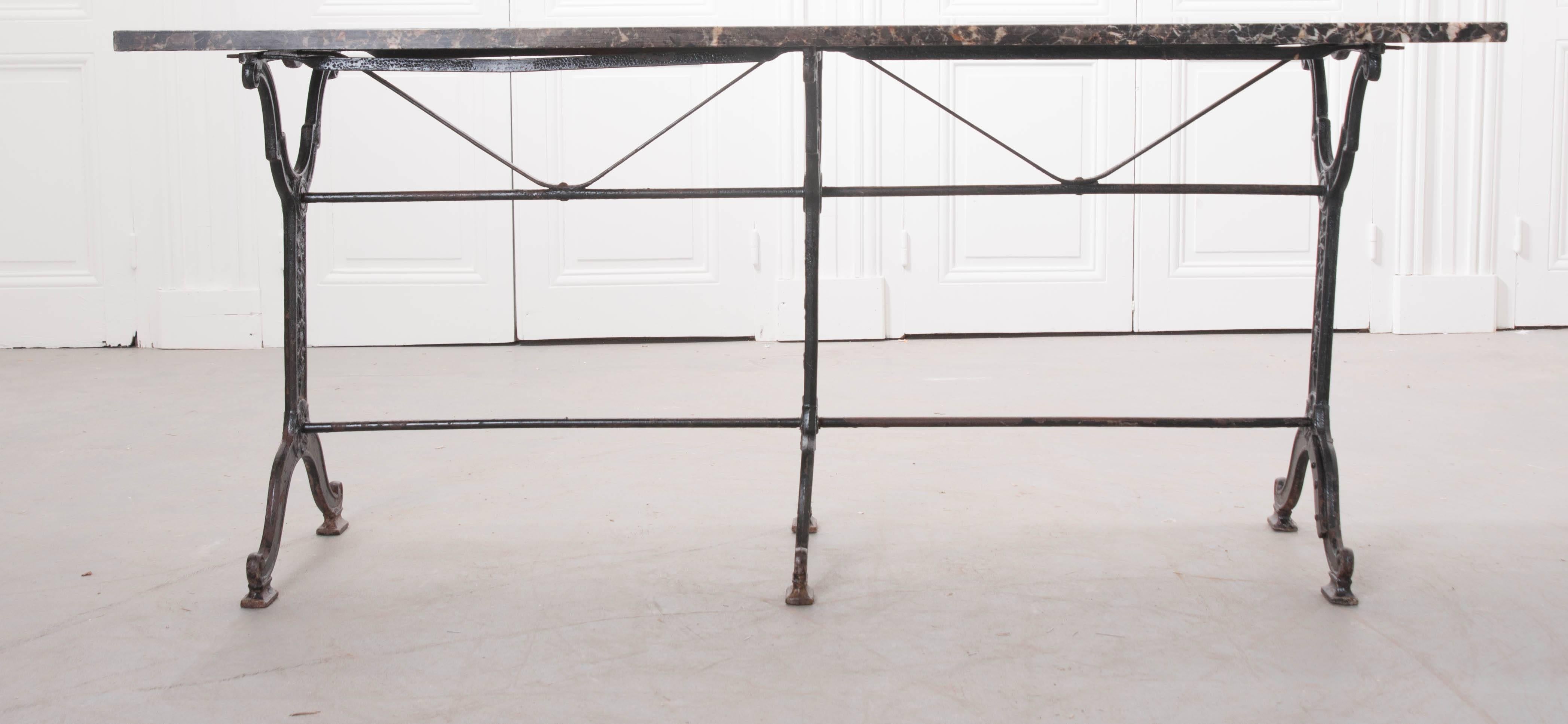 This fantastic marble-top bistro table was crafted in France, at the beginning of the 20th century. The table is unusually long, making it an ideal sofa table or hallway console. The marble top is stunning, and in remarkable condition. The cast iron