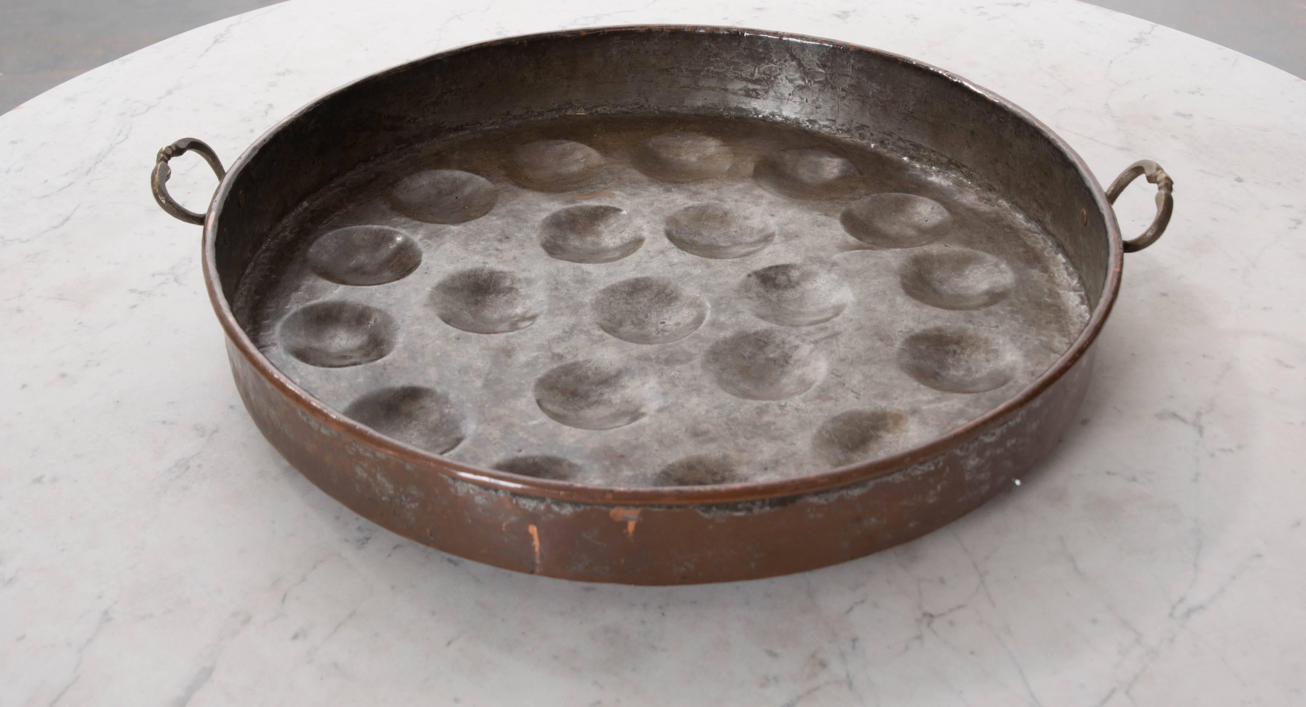 A large, well patinated copper bassine for poaching eggs, from the early part of the 19th century, France. This unique piece, with its metallic luster, will make a special addition to your kitchen or living space.

 