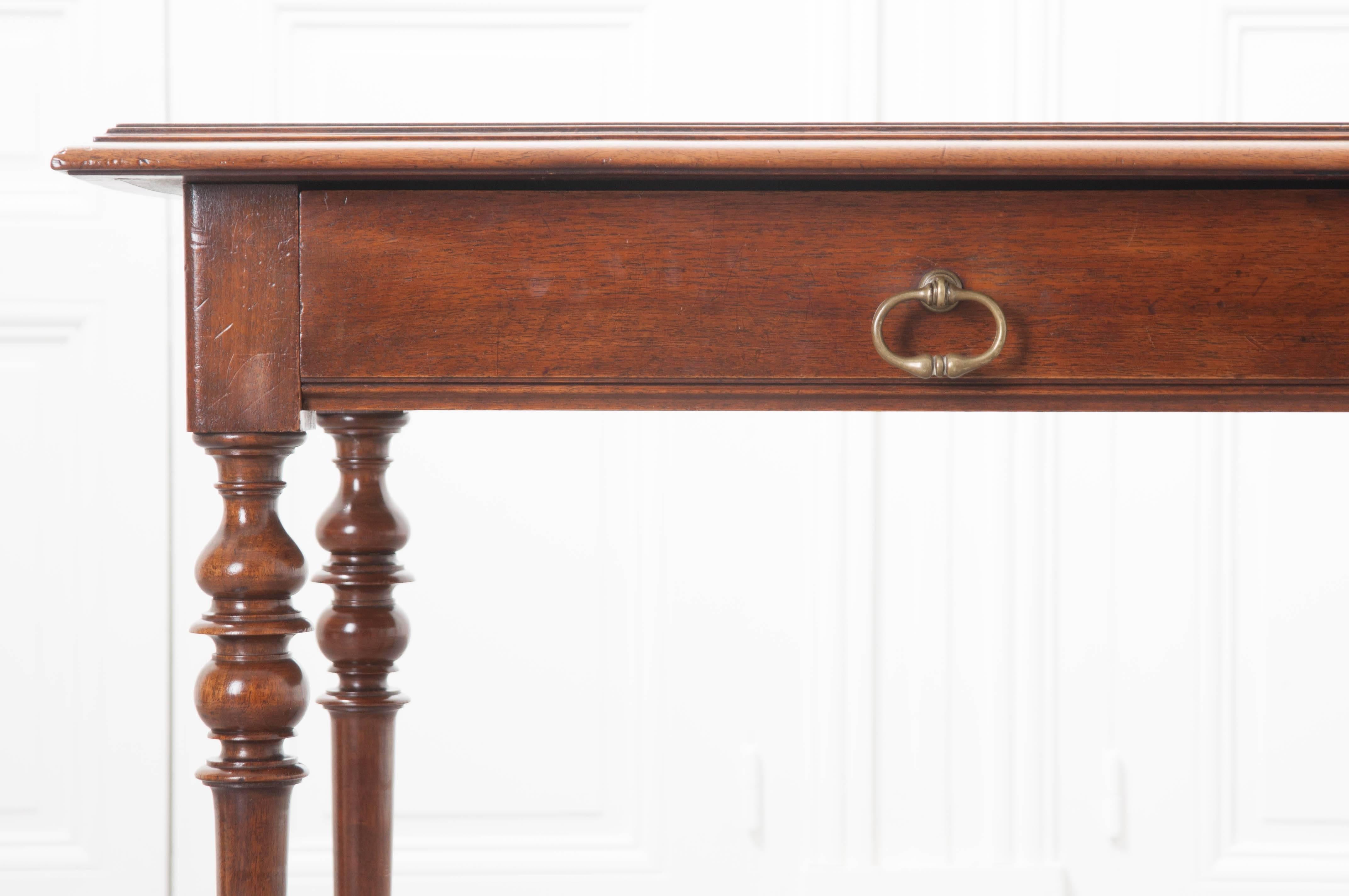 This cheery little table or writing desk was made using solid walnut, in Italy, circa 1860. The antique has a wide drawer that accounts for most of the table’s apron. This drawer has a lovely, antique brass drop-ring pull, and opens easily for out