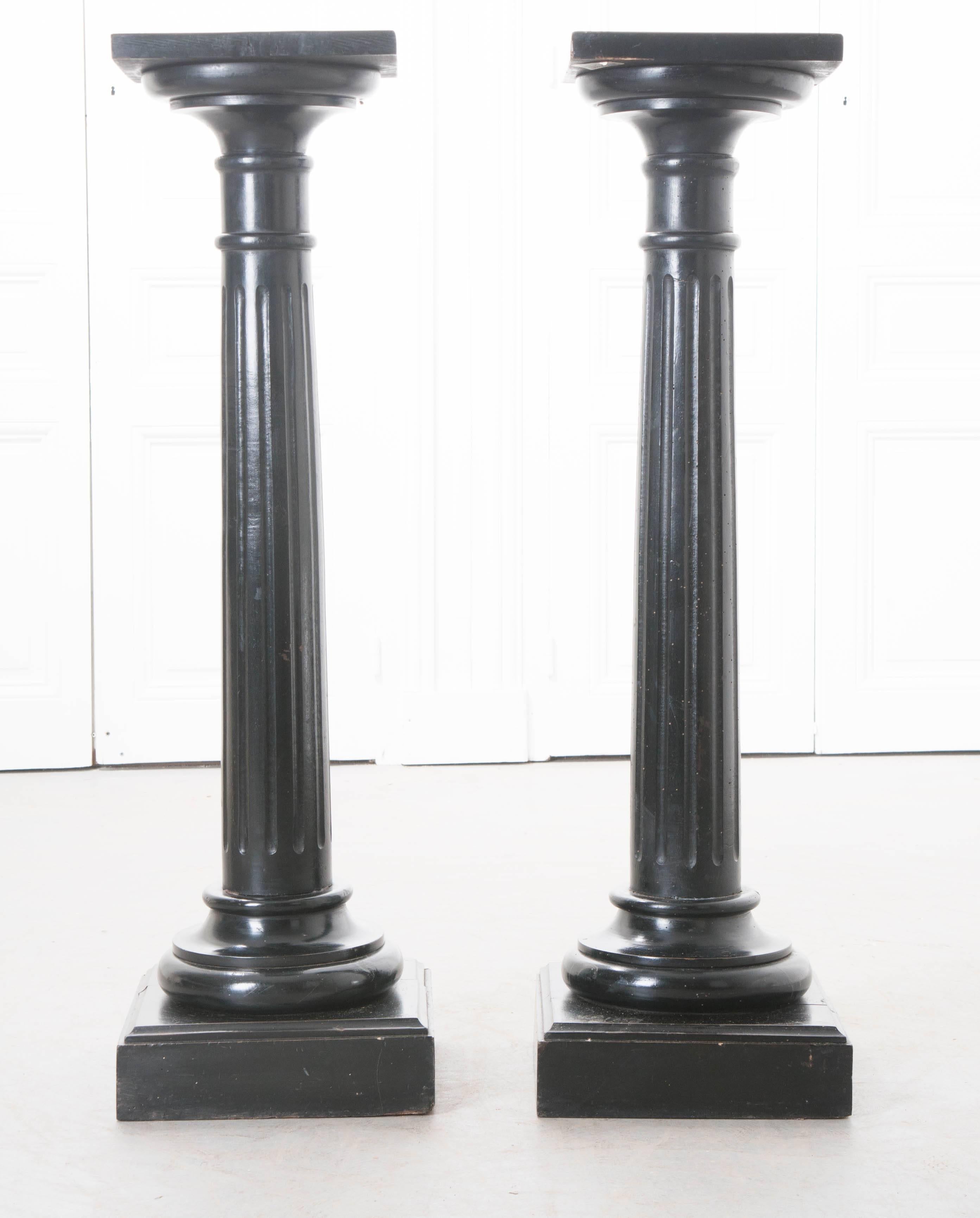 A sharp pair of ebony wood columns from 19th century, France. The round Tuscan style columns have fluted carvings, providing an additional design element to these stunning architectural pieces. The ebony pair has an excellent aged patina that is