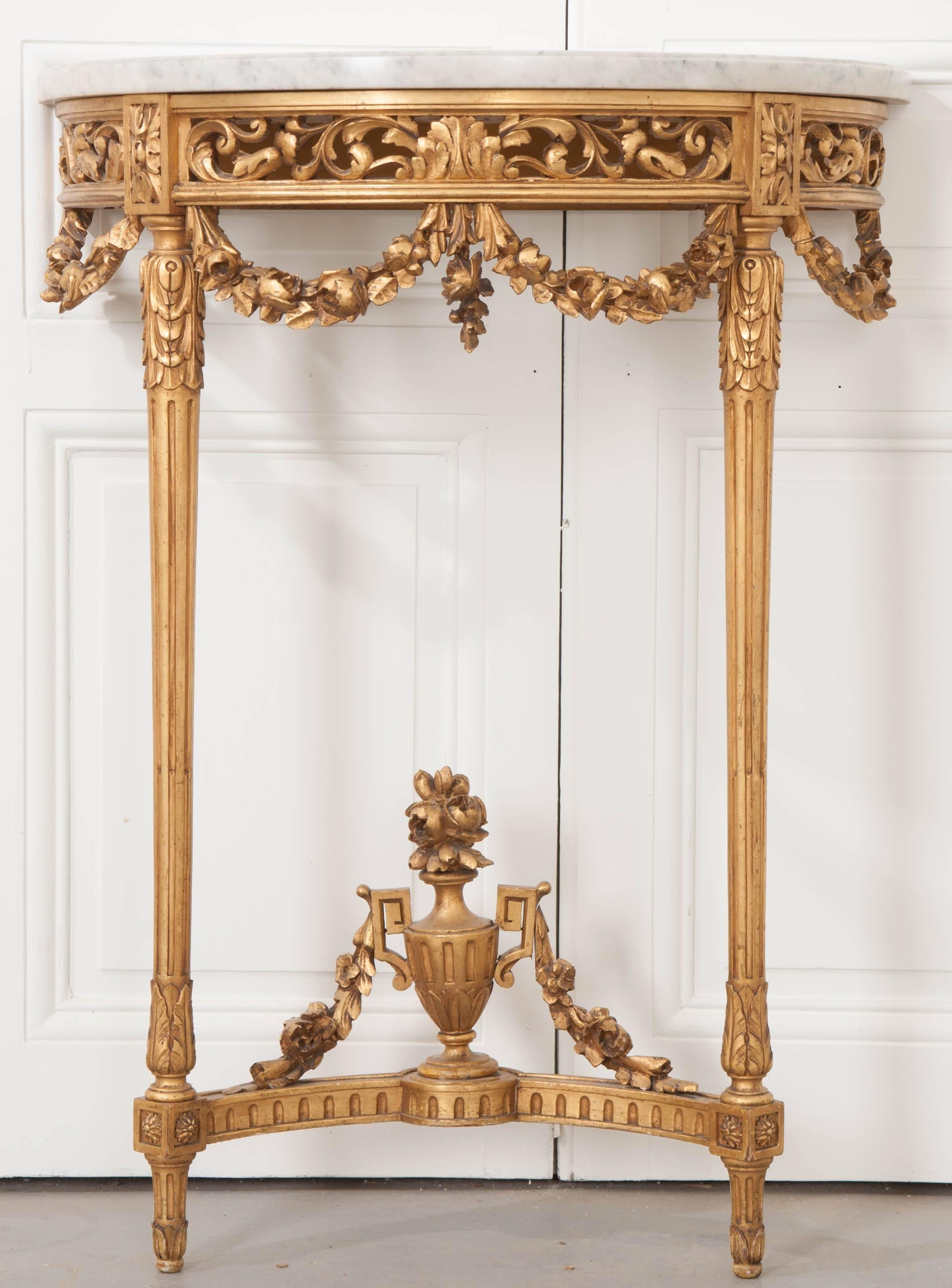 This radiant little console table was made in France, towards the middle of the 19th century. Clad in exceptionally well-preserved gold gilt, this table also boasts detailed carvings that are stunningly detailed. The gray, demilune-shaped marble top