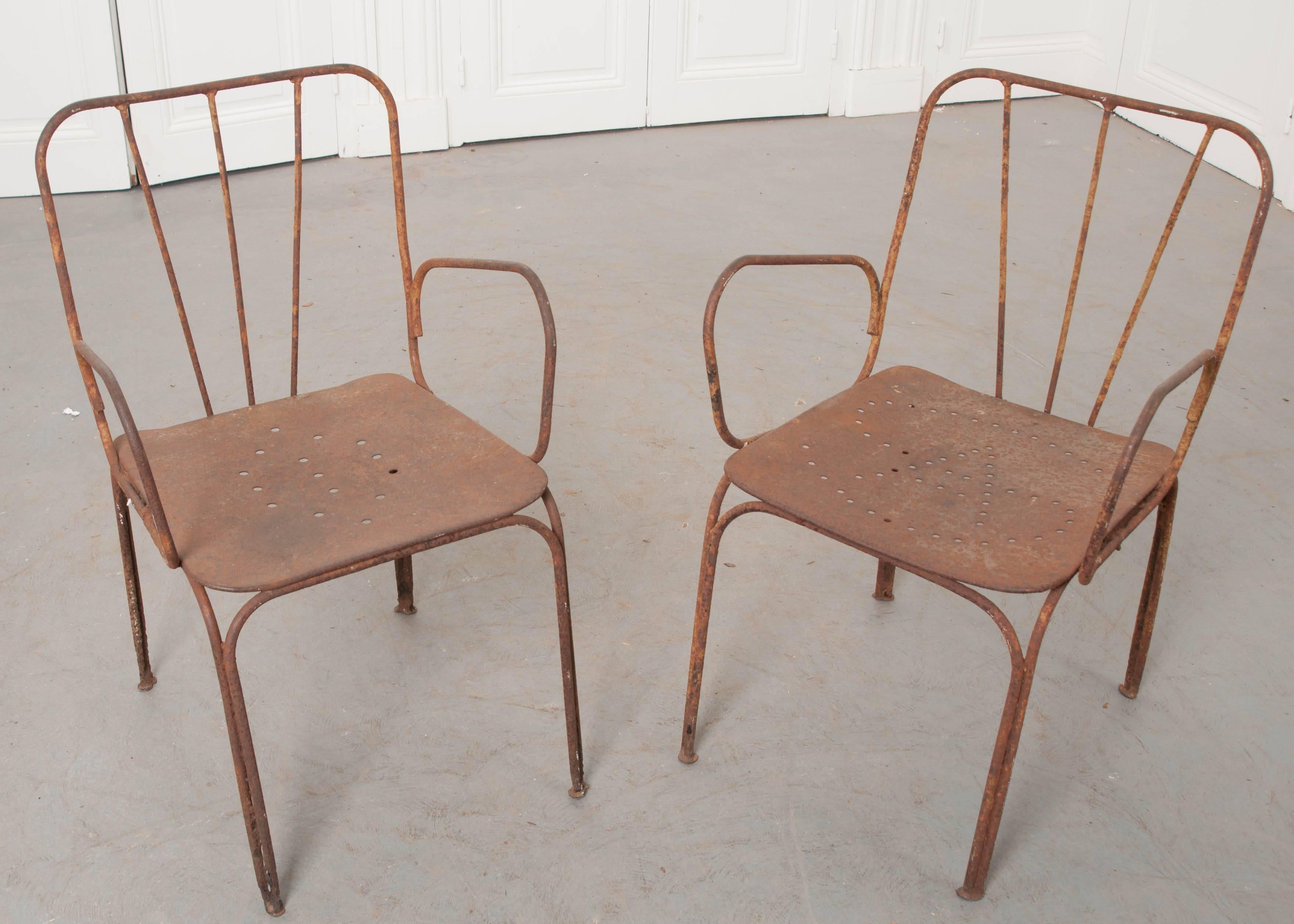 This fantastic pair of metal chairs were made in France near the turn of the century. We absolutely love the patina they have acquired through the years, as well as their clever, yet uncomplicated design! A fabulous pair for the garden or