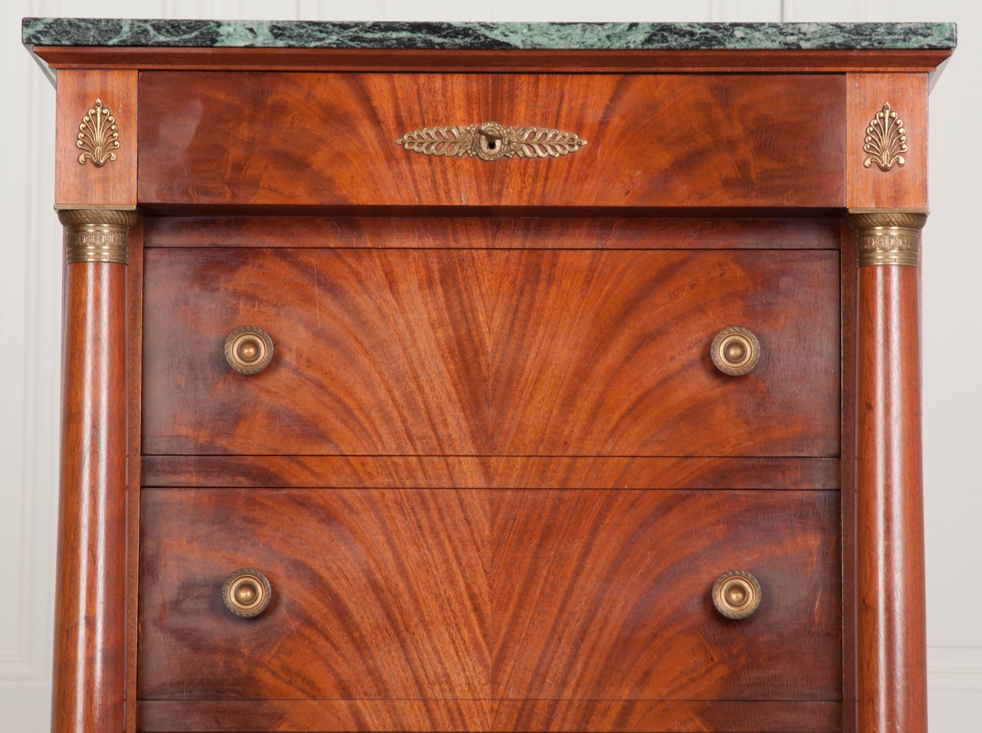 A fine mahogany lingerie commode, done in the Empire style, and made in France, circa 1940. An extremely well-preserved piece of marble sits atop this handsome antique. The commode contains seven total drawers. The topmost drawer lacks pulls, but