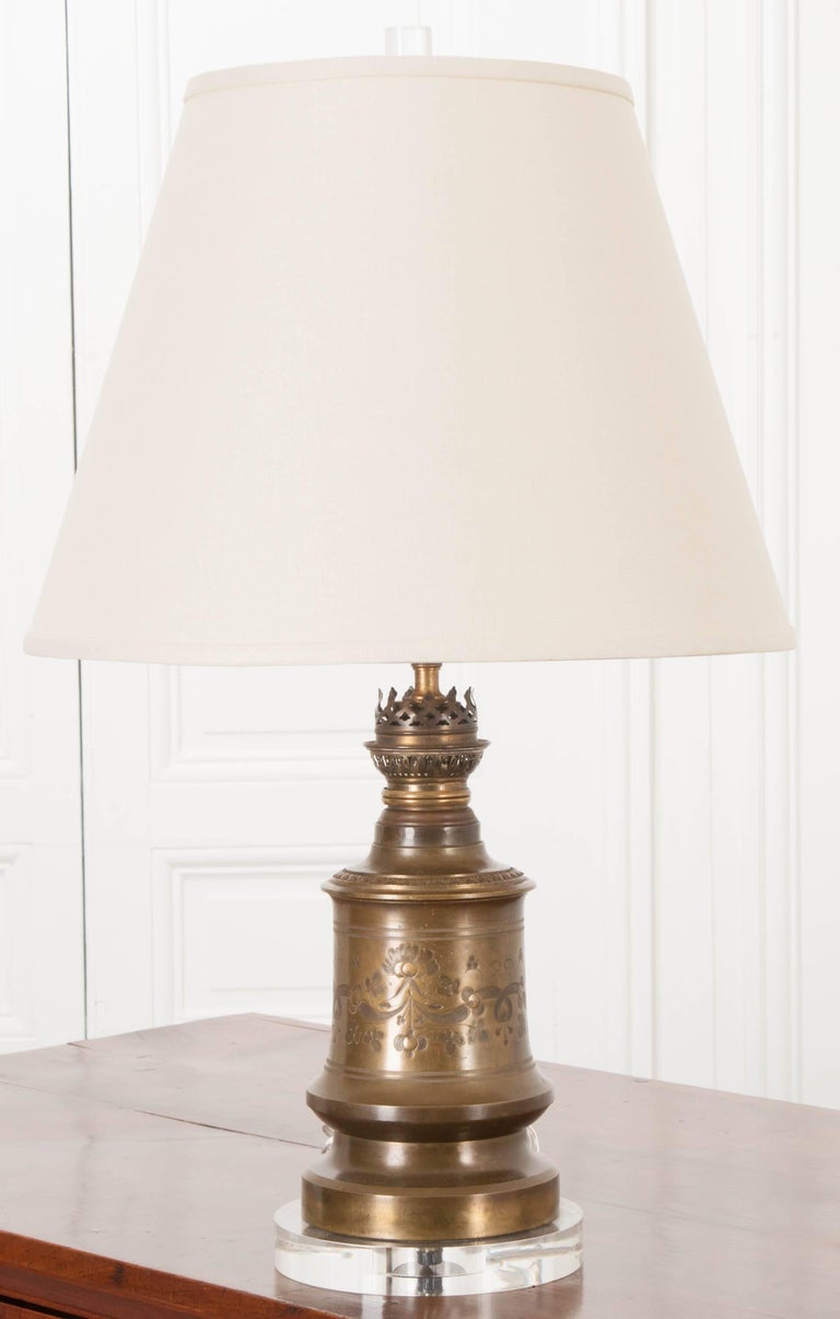 A newly made lamp, made from a component from an antique French lamp. The brass base is exceptionally styled with etched flowers and scrolled foliage. There is a pierced gallery that encircles the neck. The antique piece has been mounted onto a