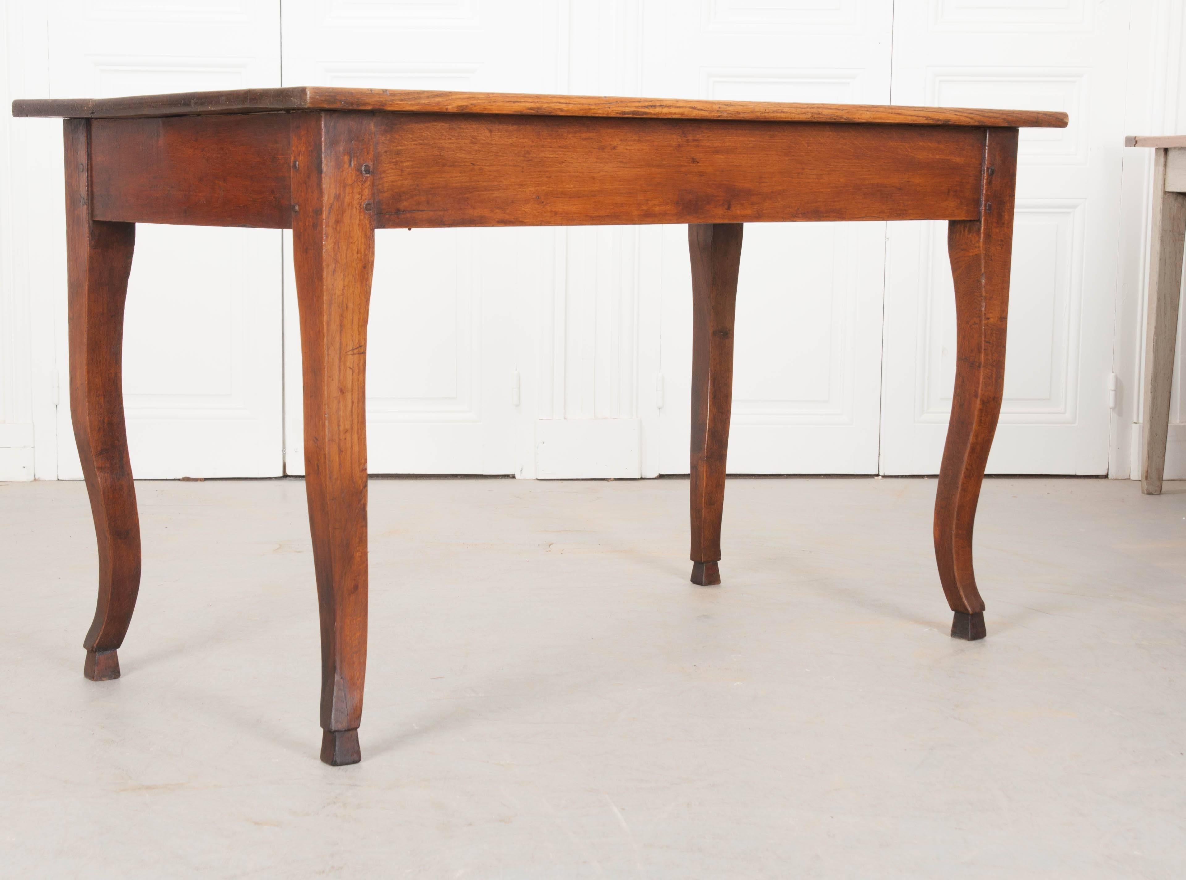 A wonderful oak dining table, with hand-carved cabriole legs, from 19th century, France. This smaller dining table would be best suited for a breakfast room, kitchen, or small dining space. Ideal for someone with limited space, the table is charming